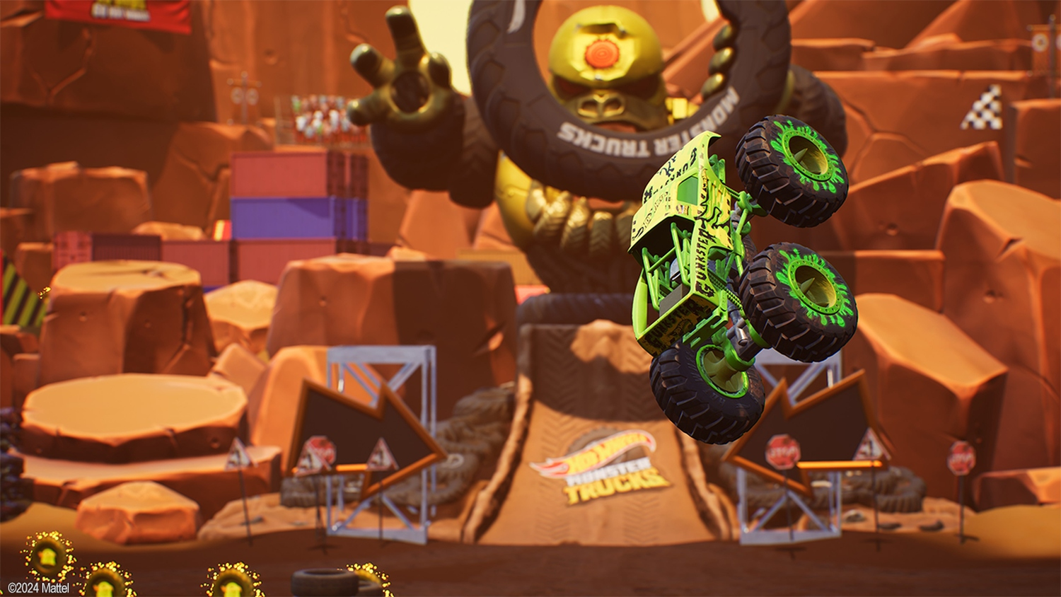 Ein grüner Monstertruck namens "Funkster" springt. Riesige goldene Monsterfigur im Hintergrund, Stadion mit Hindernissen und Dirt-Rampen.