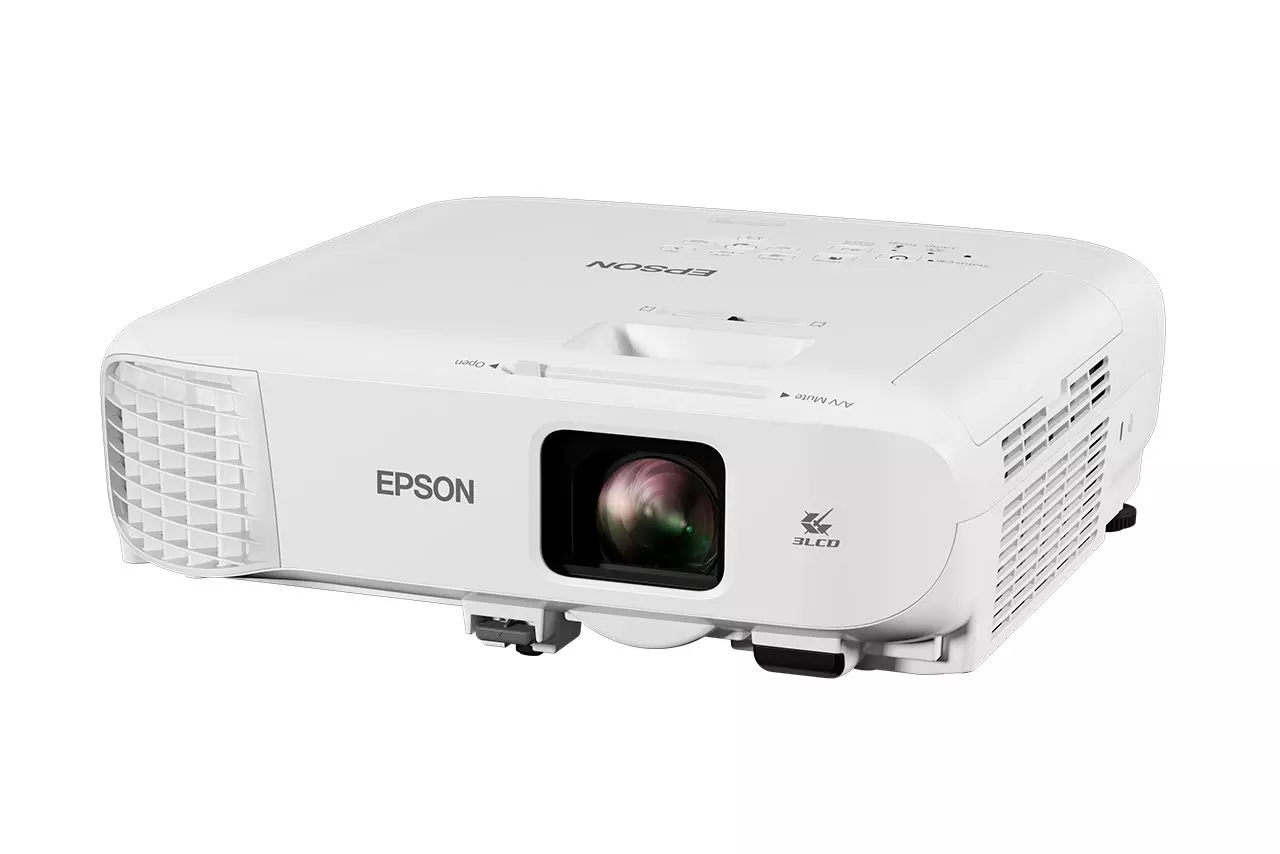 Egy fehér Epson projektor látható, enyhén megdöntve. Van lencséje, szellőzése és vezérlőgombjai. A márkanév látható.