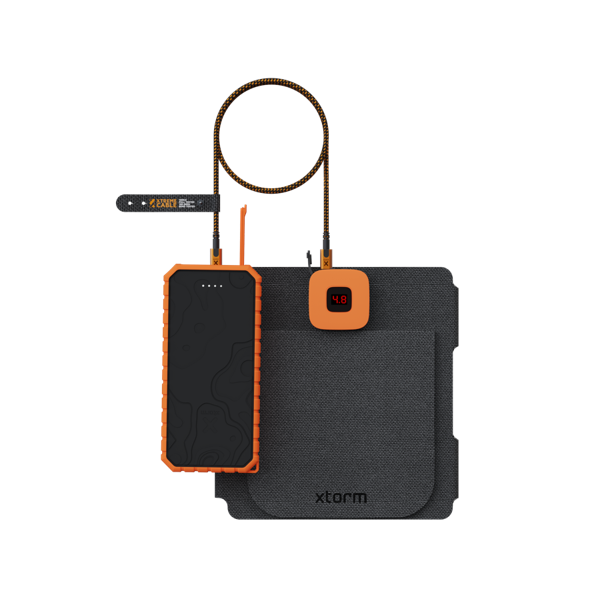 Un banco de energía naranja y negro, conectado a una almohadilla gris y una pequeña pantalla con un cable marrón y naranja. La pantalla muestra '4.8'.