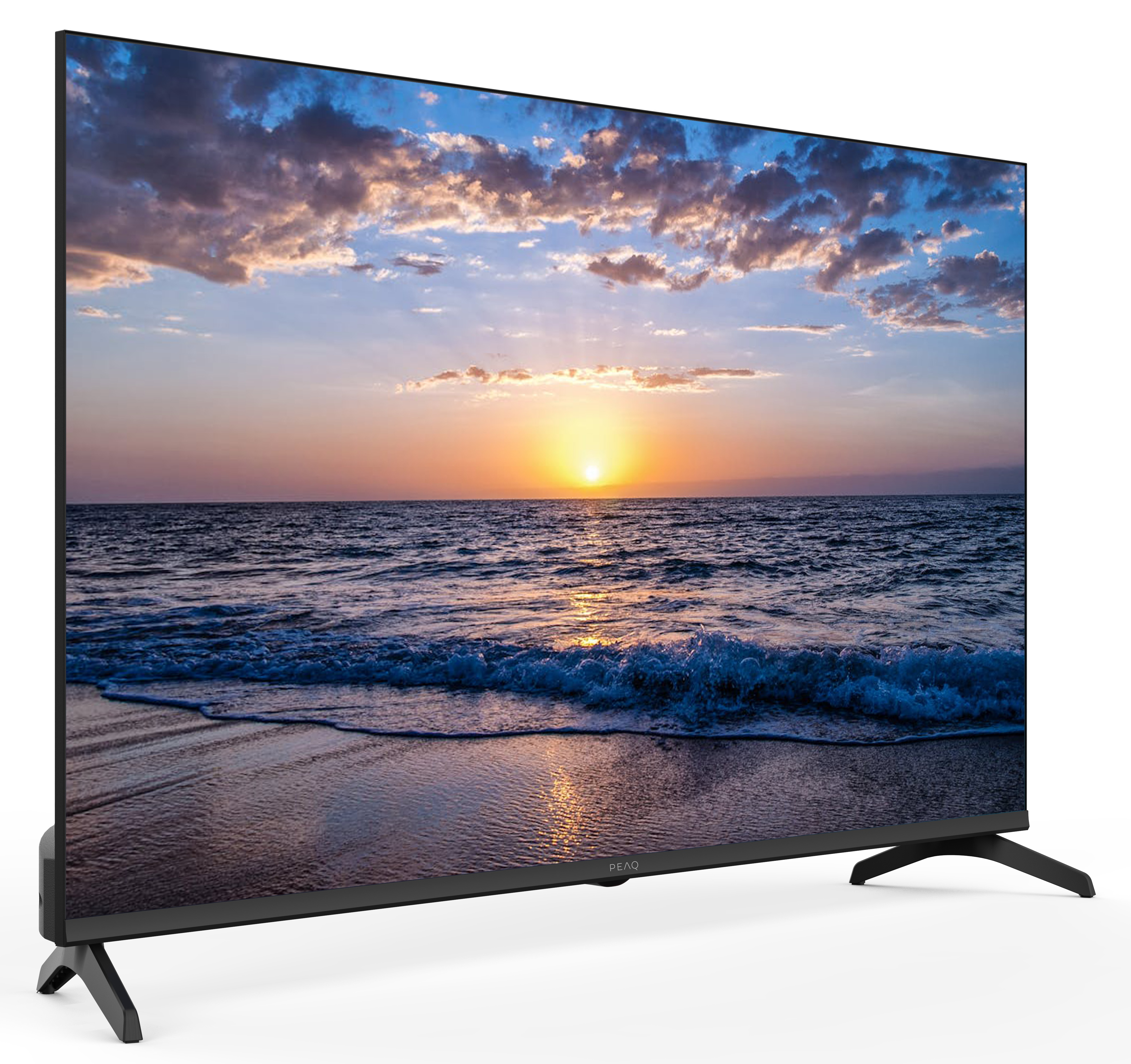 Telewizor wyświetla zachód słońca nad oceanem. Na niebie są chmury. Telewizor stoi na białej powierzchni.