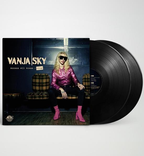 Vanja Sky Albumcover. Frau in rosa Jacke, schwarzer Hose und Sonnenbrille sitzt auf einer Bank. Zwei schwarze Schallplatten rechts.