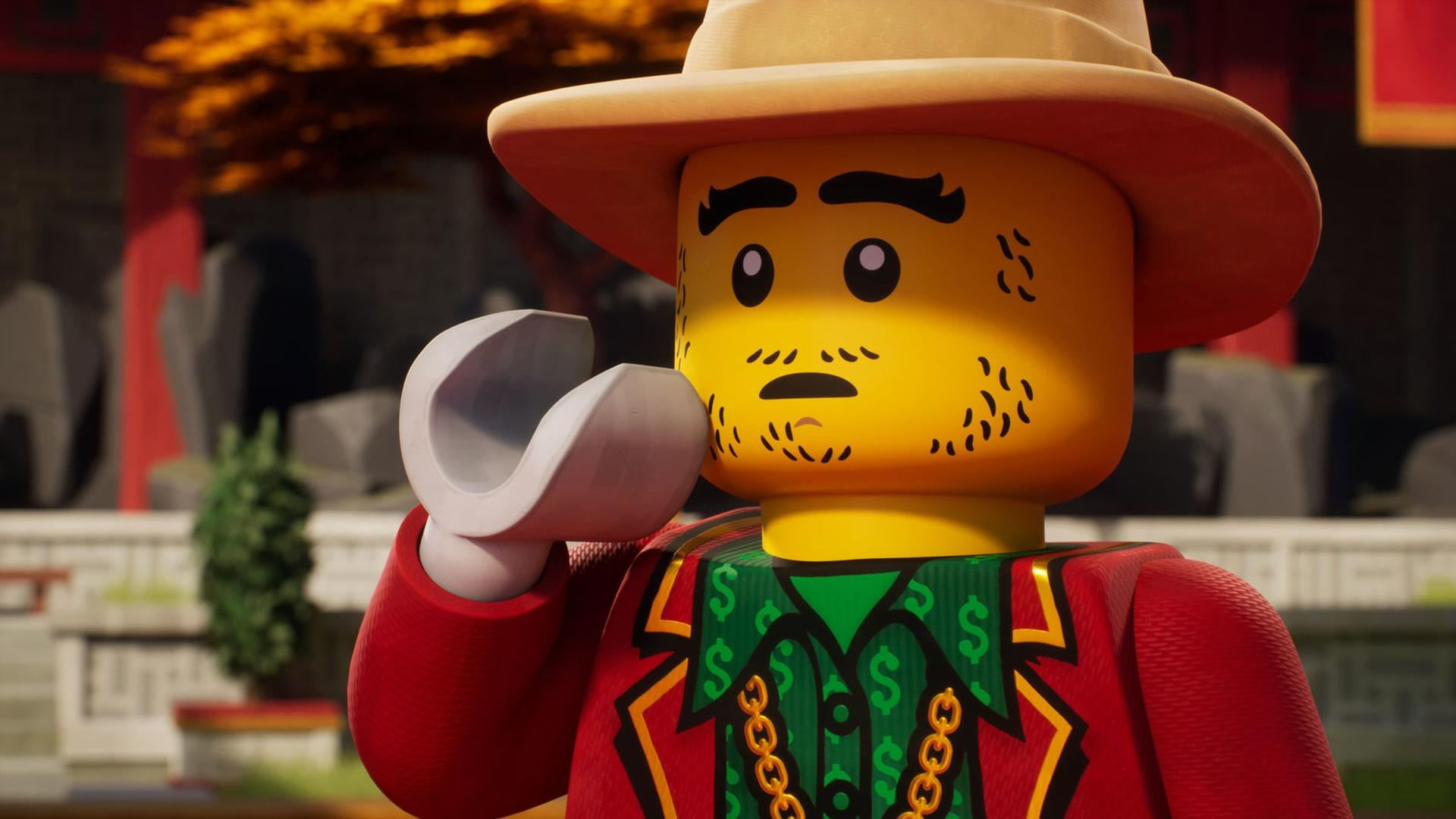 Eine Lego-Figur mit Hut, roter Jacke und Dollarzeichen-Hemd. Es hält ein graues Objekt. Im Hintergrund sind ein Gebäude und Bäume zu sehen.