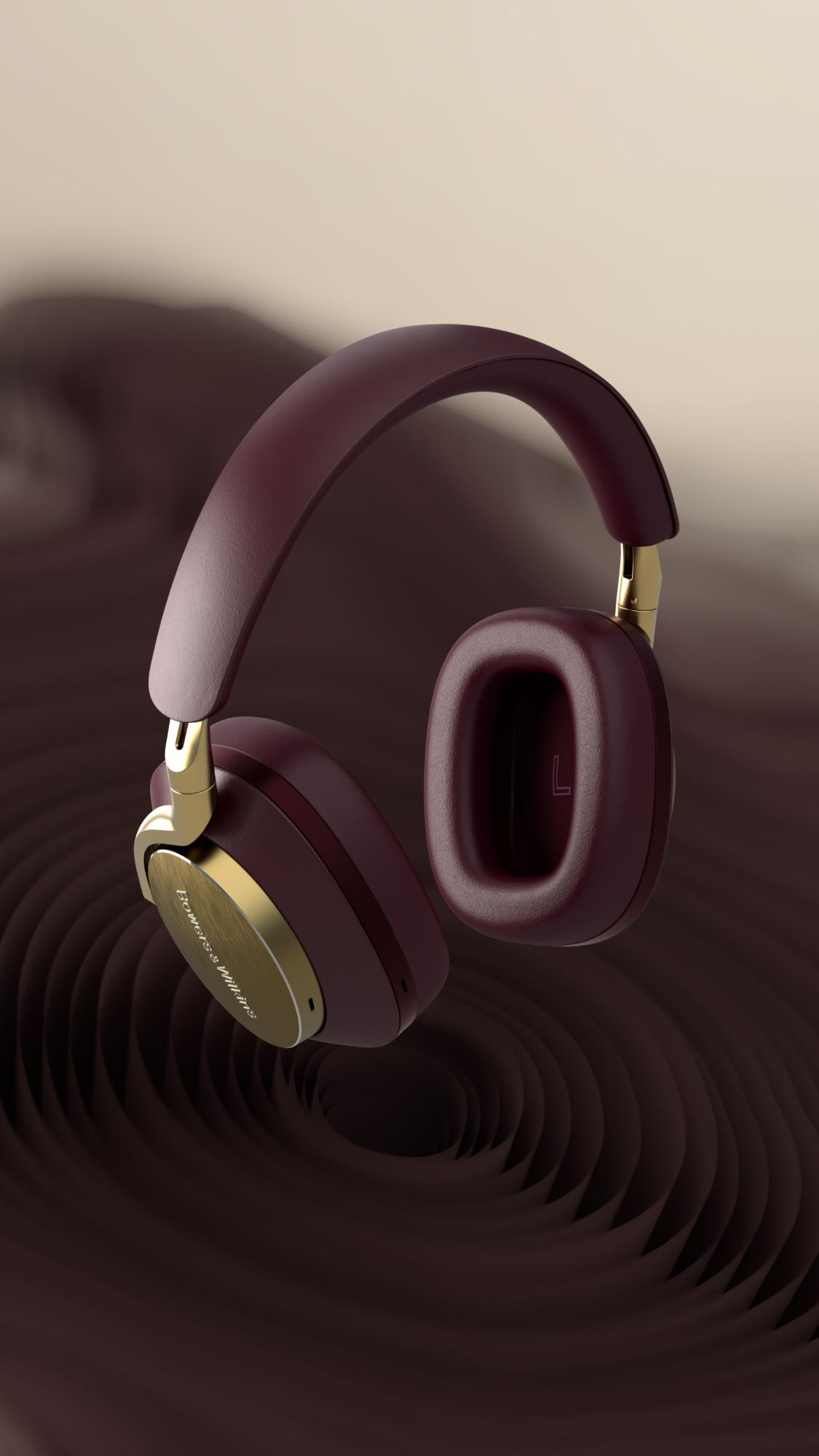 Burgunderfarbene Kopfhörer mit goldenen Akzenten, die vor einem wirbelnden braunen Hintergrund schweben. Der Markenname lautet Bowers & Wilkins.