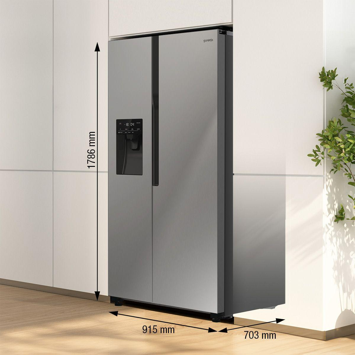 Chłodziarka Gorenje side-by-side ze stali nierdzewnej. Wymiary: 1786 mm wysokości, 915 mm szerokości i 703 mm głębokości. Widoczne są zielone rośliny.