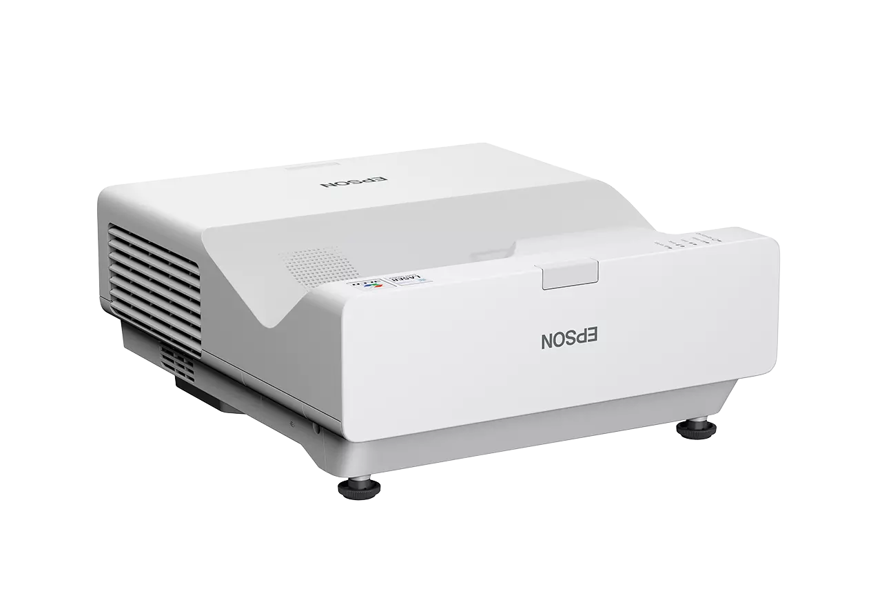 Egy fehér EPSON projektor fekete felületen. EPSON logóval rendelkezik, és oldalsó szellőzővel.