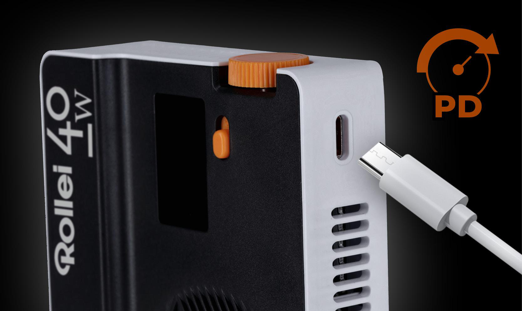 Rollei 40W Gerät mit eingestecktem USB-C-Kabel. Orangefarbene Wählscheibe und Akzente. Schwarz-weißes Farbschema. PD-Symbol vorhanden.