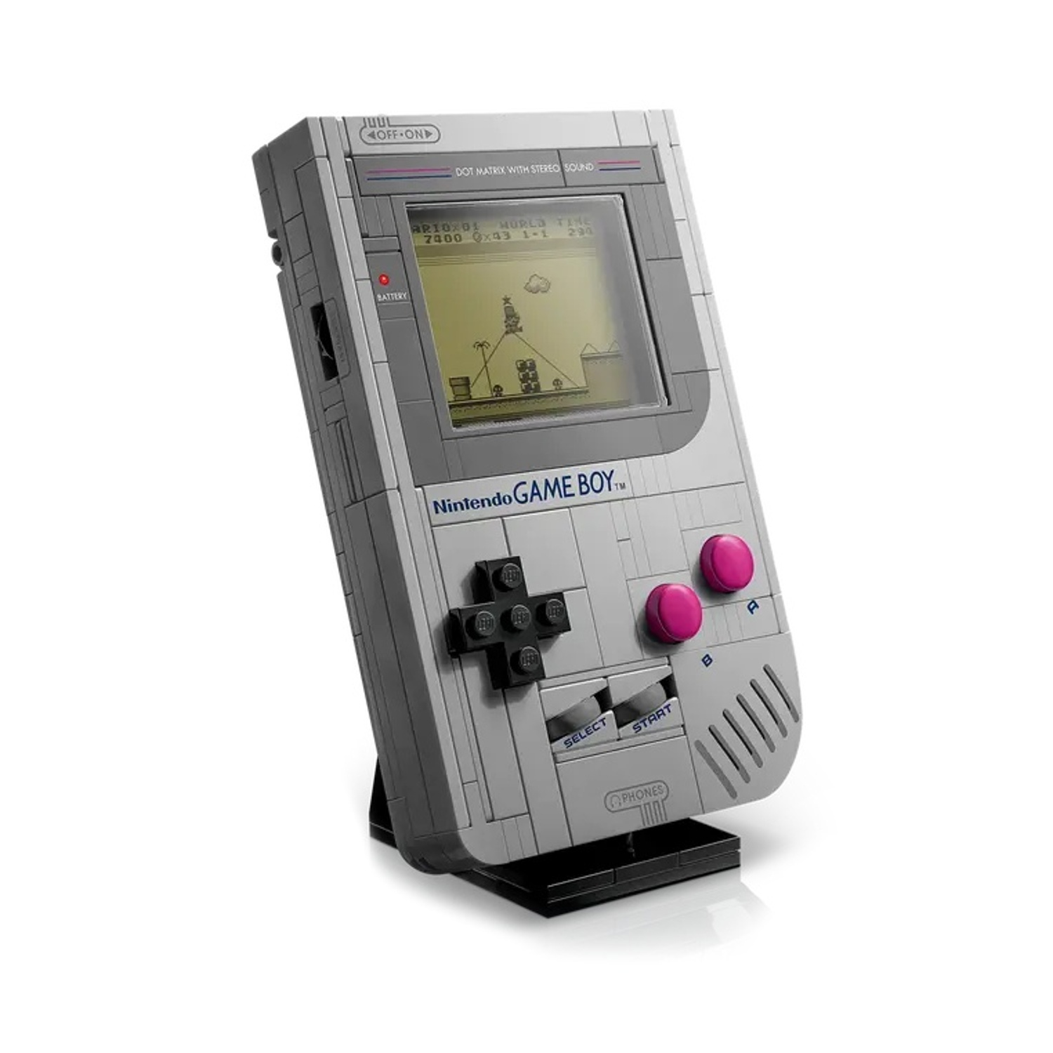 Un set Lego Game Boy su un supporto nero. Lo schermo mostra un gioco pixelato. Ha pulsanti rosa e un D-pad nero.
