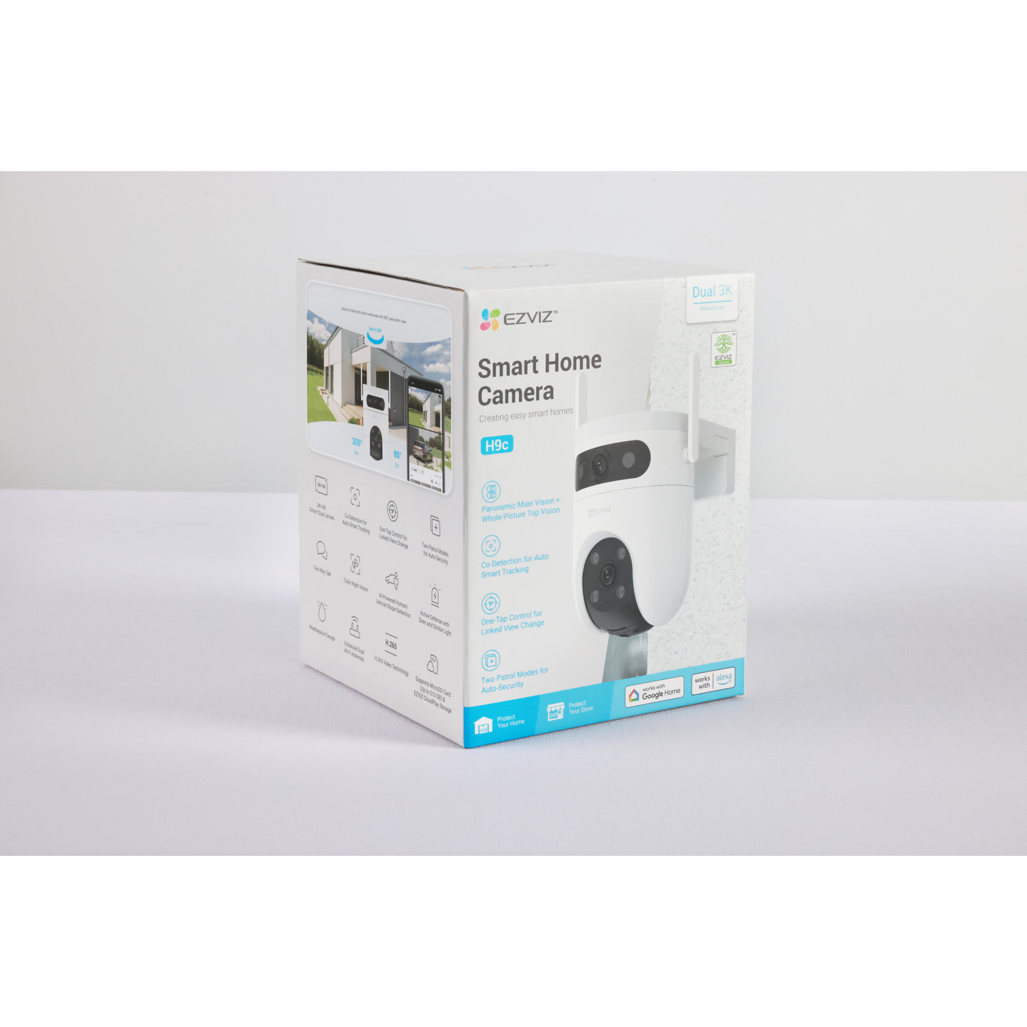 A white EZVIZ Smart Home Camera box and the camera itself are on a white surface. The box displays features and a house image.