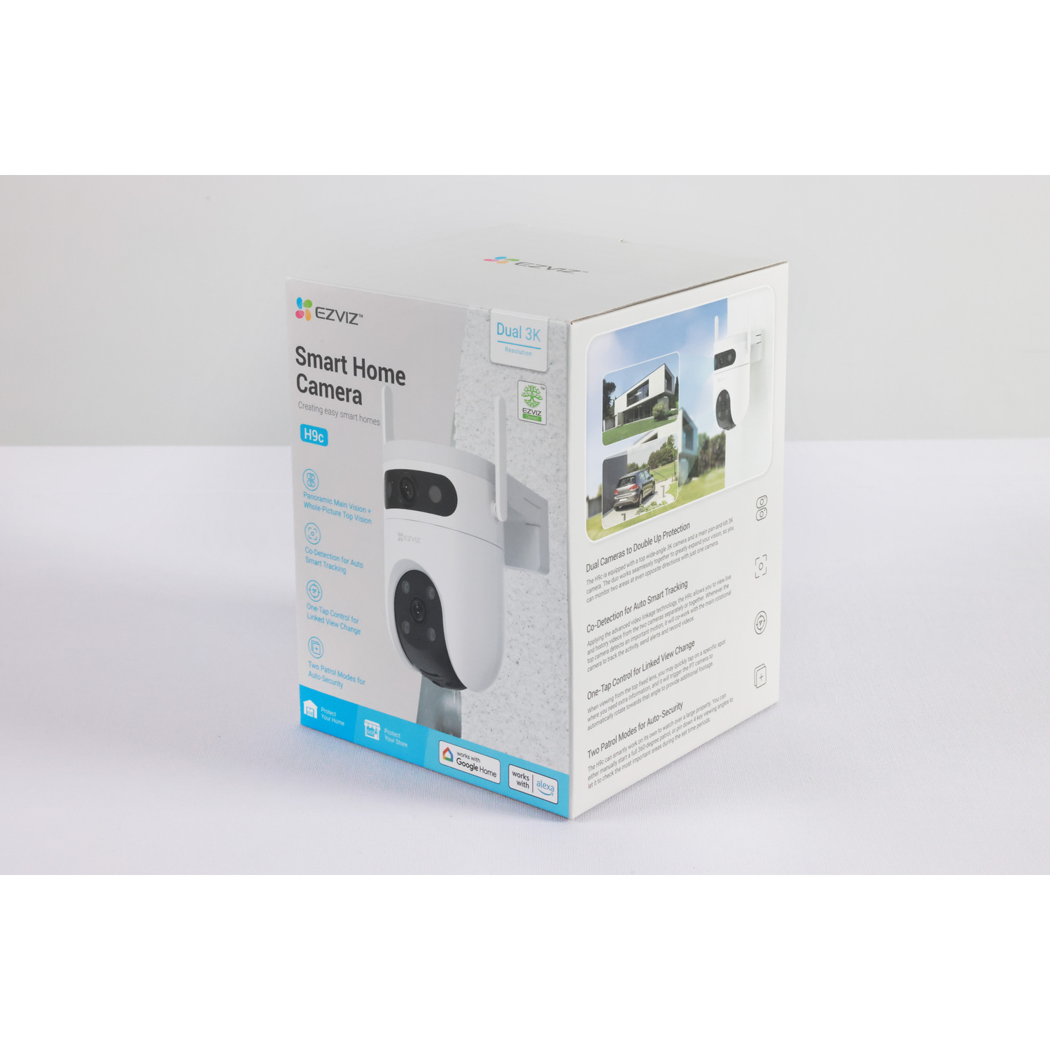 Box of a smart home camera. It features a white camera with a black lens. Text on the box describes its features.