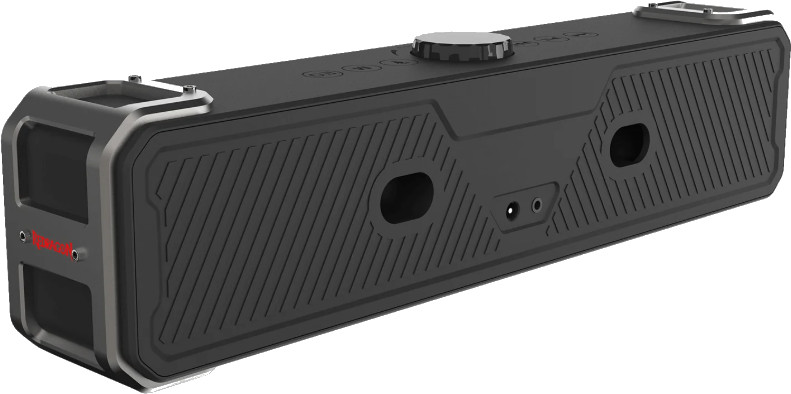 Czarny prostokątny głośnik ze srebrnymi akcentami, przyciskami i otworami. Ma teksturowaną powierzchnię i małe srebrne pokrętło na górze.