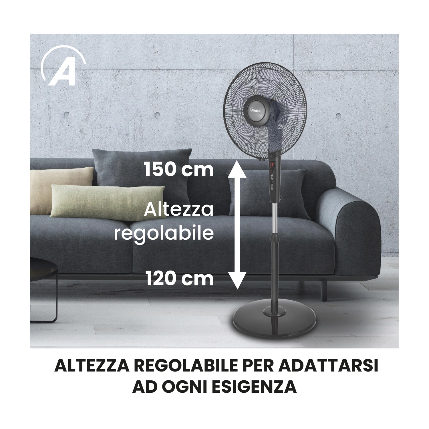 Un ventilatore nero in piedi è di fronte a un divano grigio con cuscini. Il ventilatore ha un'altezza di 120-150 cm. Lo sfondo è un muro grigio.