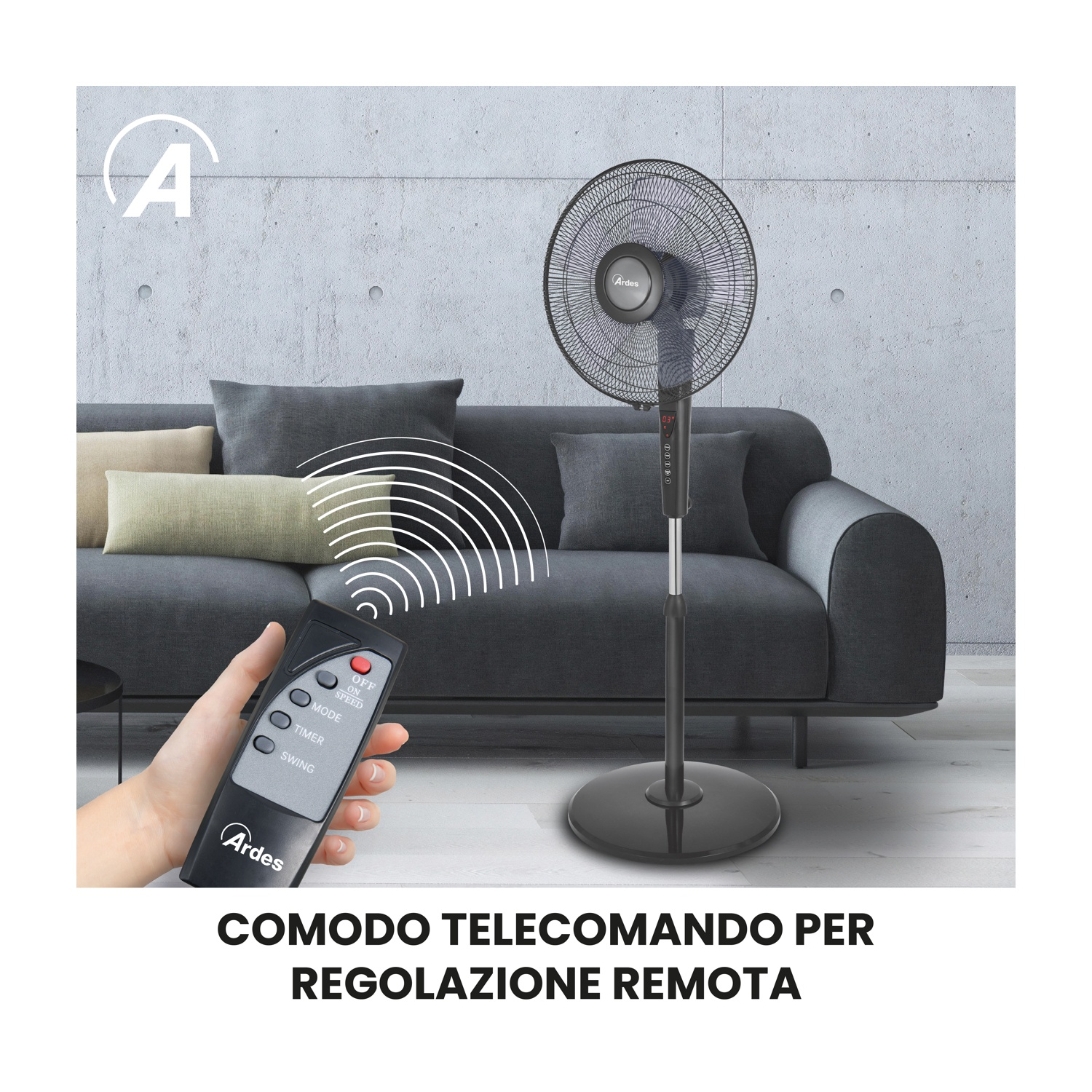 Una mano tiene un telecomando verso un ventilatore nero. Un divano grigio con cuscini è sullo sfondo.