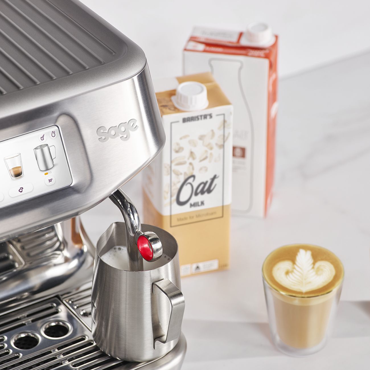 Macchina per caffè espresso con schiumatore per latte, cartone di latte d'avena e latte art a foglia.