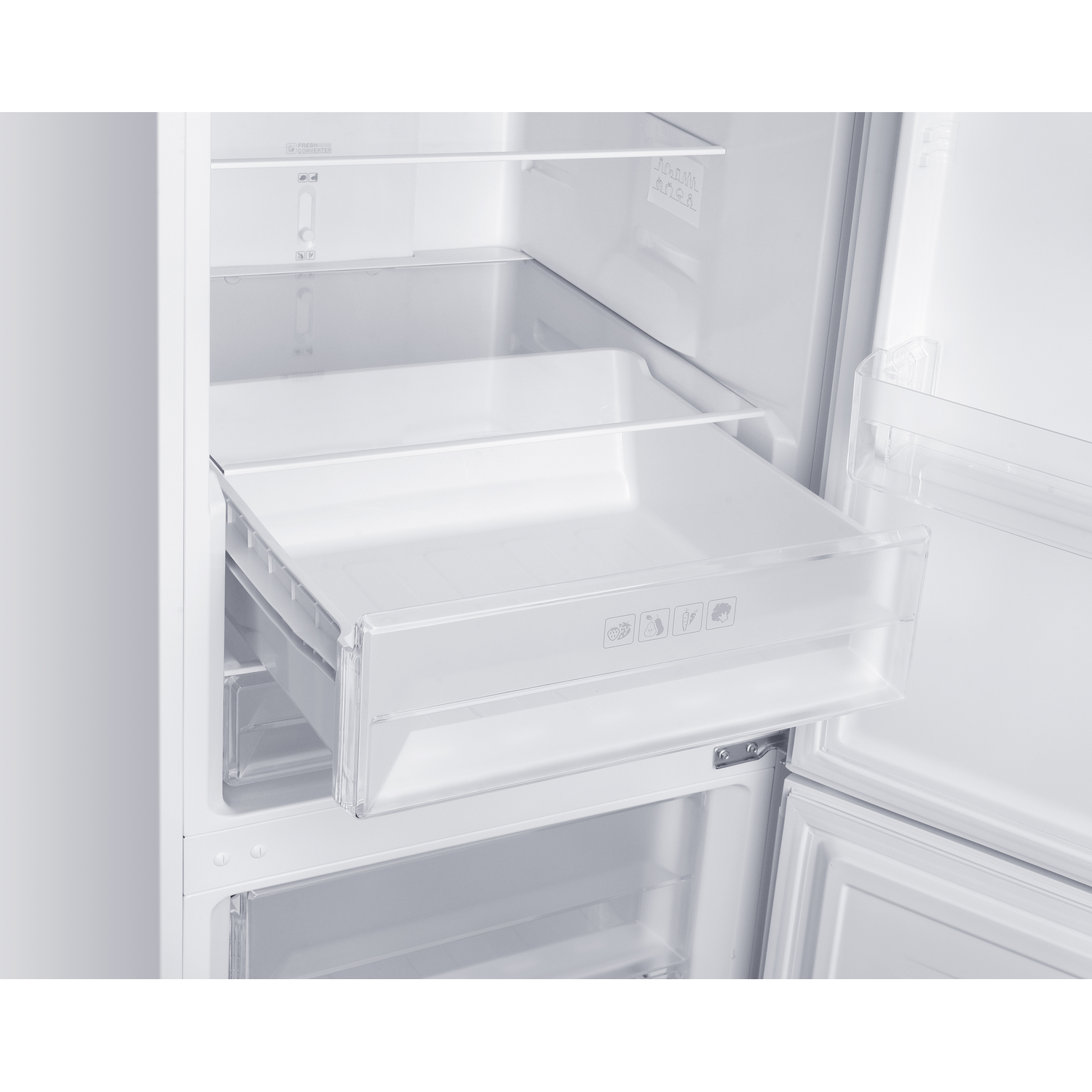 An open white refrigerator. A drawer is pulled out. Inside, there are shelves. The inside of the door is also visible.