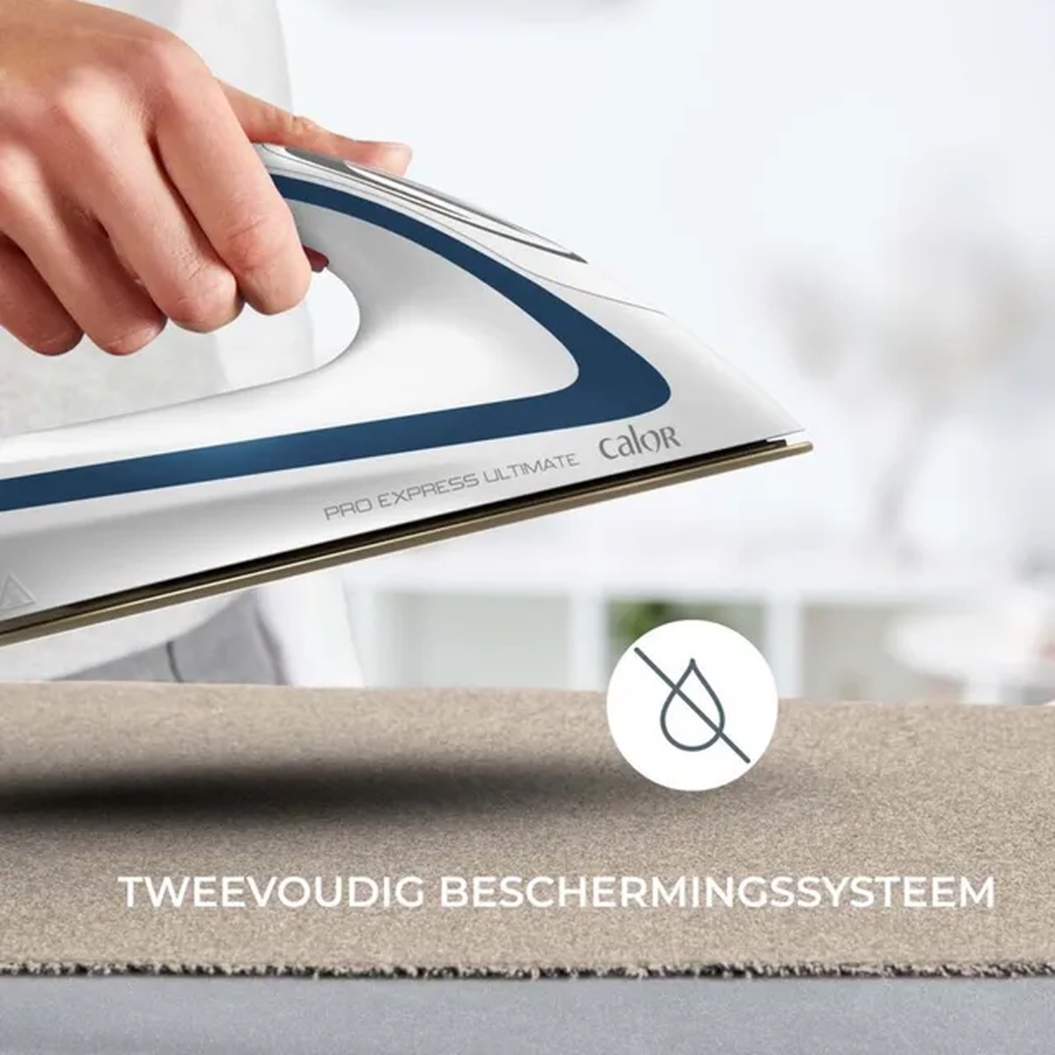 A hand holds a white and blue iron over fabric. The iron has "Calor" written on it. A no-drip symbol is also visible.