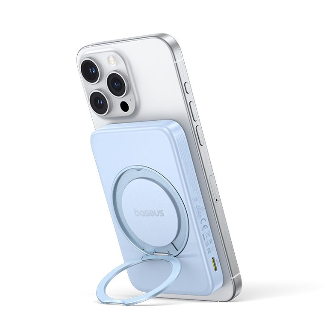 Açık mavi bir Baseus manyetik güç bankası, gümüş bir iPhone'un arkasına takılıdır. Güç bankasının halka şeklinde bir standı var.