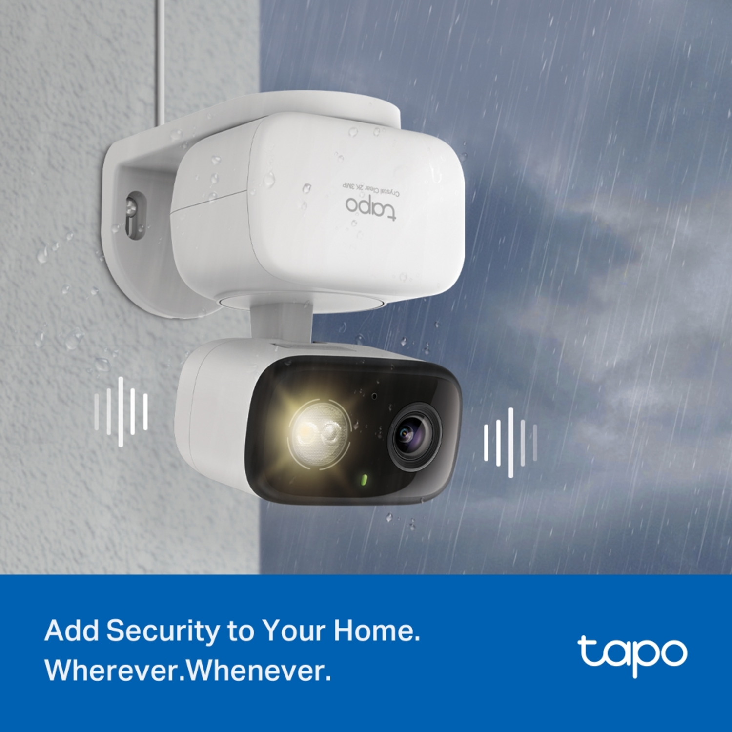 A white Tapo security camera is mounted on a wall in the rain. The camera has a light and lens, with branding visible.