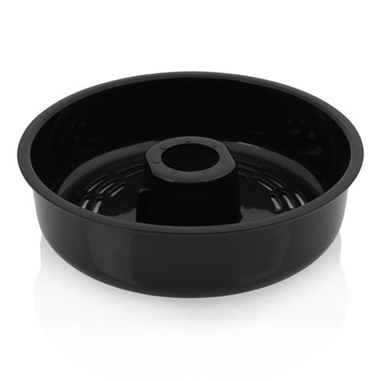 A black bundt cake pan, round with a central tube. It sits on a white surface, the pan reflecting the light.