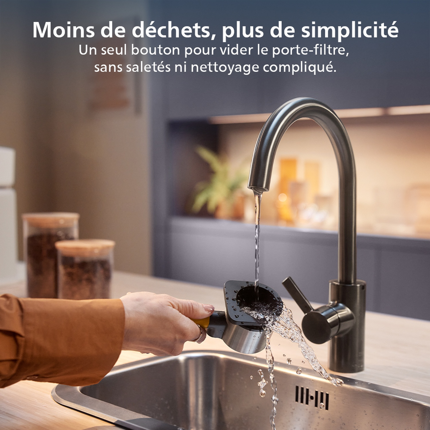 Une main vide un filtre à café dans un évier sous un robinet noir. L'eau coule. Texte : 'Moins de déchets, plus de simplicité'.