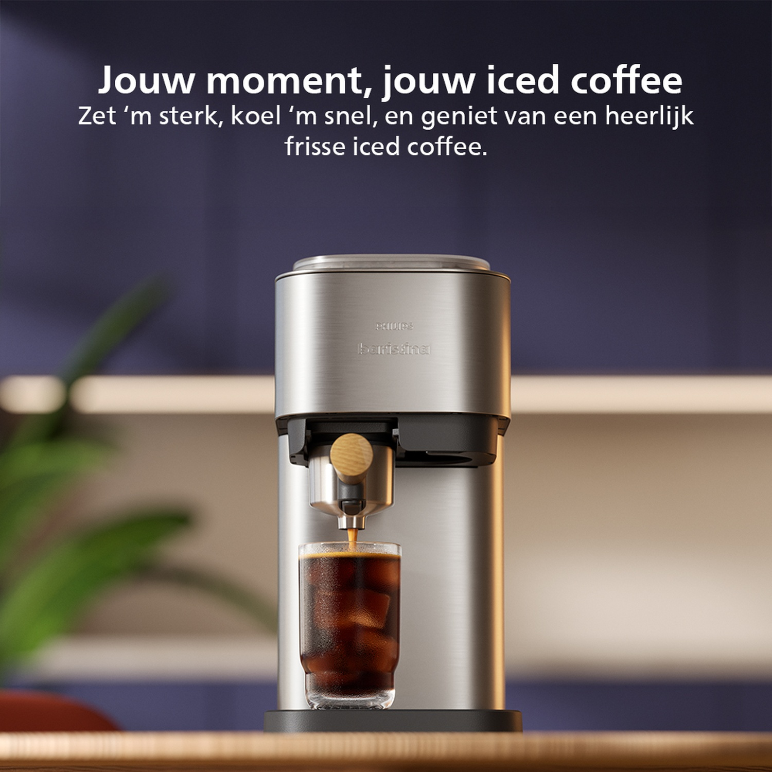 Une machine à café argentée verse du café dans un verre avec des glaçons. Le fond présente du texte et un intérieur flou.
