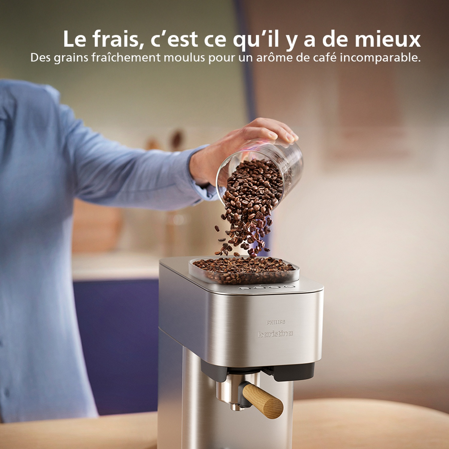 Une personne verse des grains de café dans une cafetière argentée. La scène est bien éclairée, avec un focus sur la préparation du café.