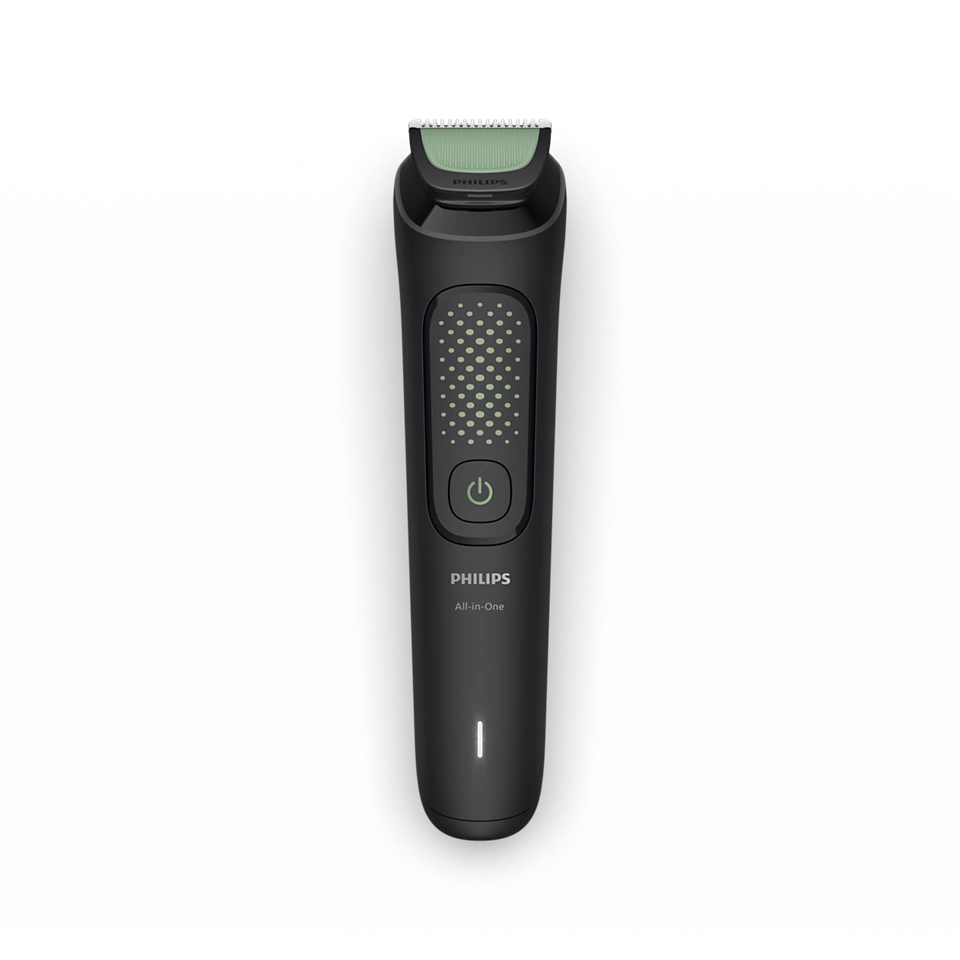 Fekete Philips All-in-One trimmer zöld pengével. Van rajta egy bekapcsológomb és egy fényjelző. A háttér fekete.