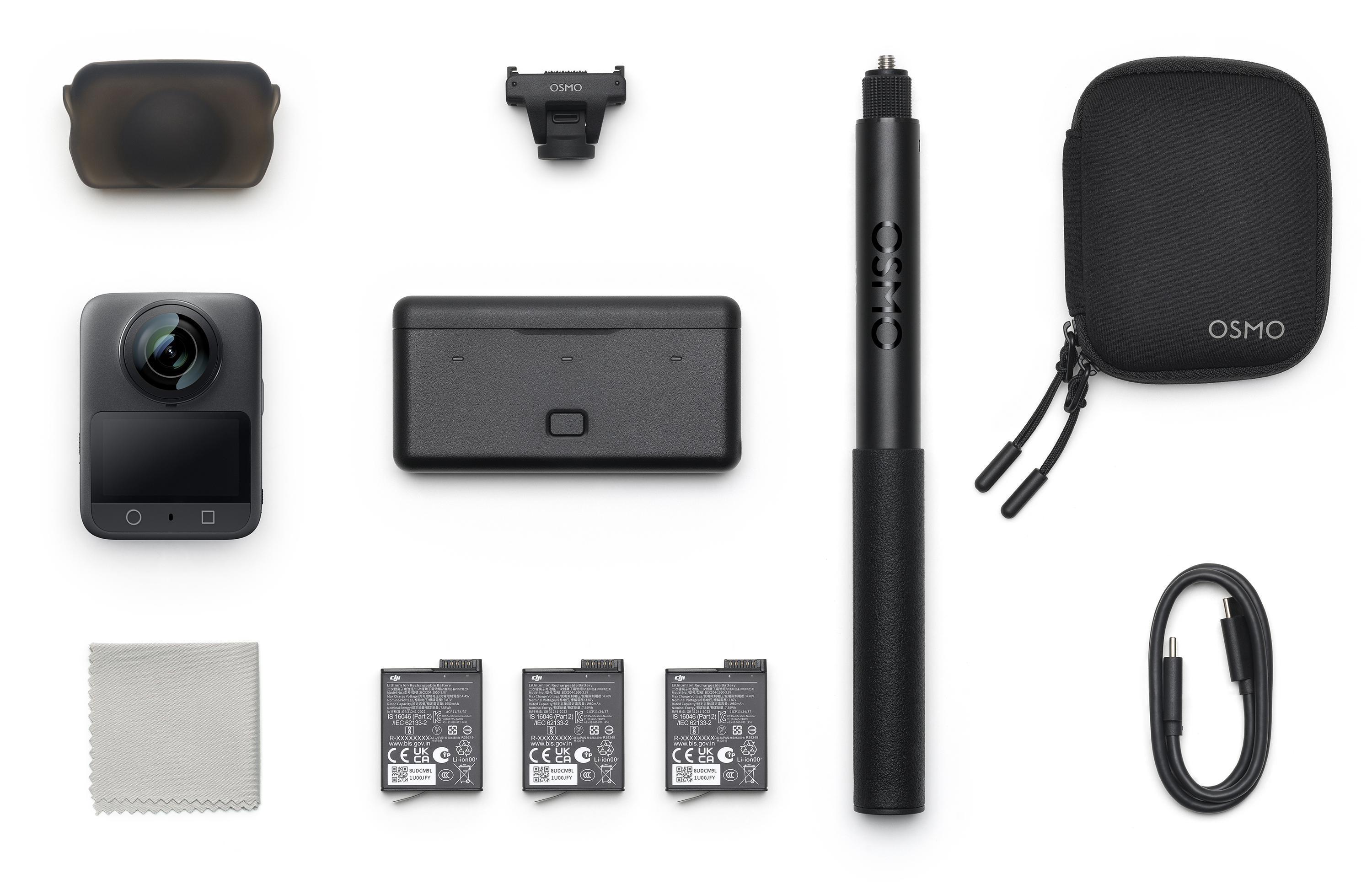 DJI Osmo kamerakészlet fehér felületen. Tartalmaz kamerát, tokot, akkumulátorokat és tartozékokat.