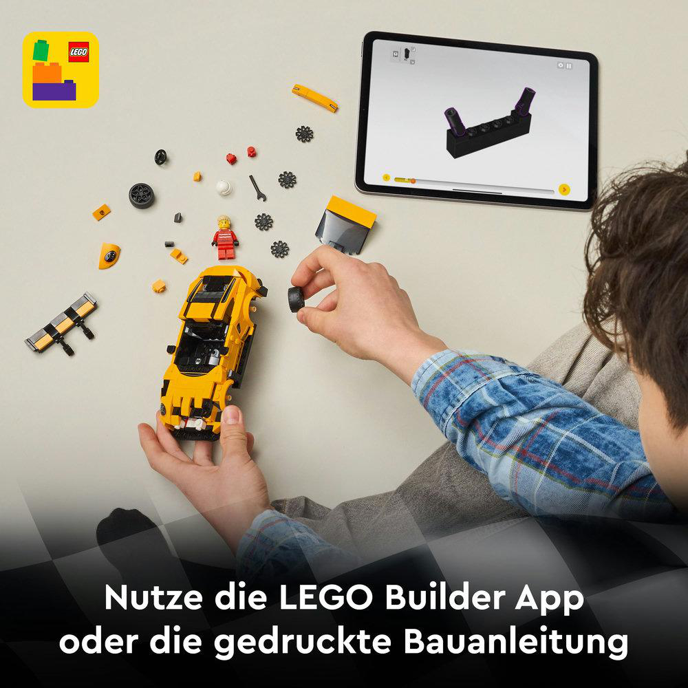 Eine Person baut ein gelbes Lego-Auto zusammen. Teile sind verstreut. Ein Tablet zeigt Anweisungen. Lego-Logo oben links.