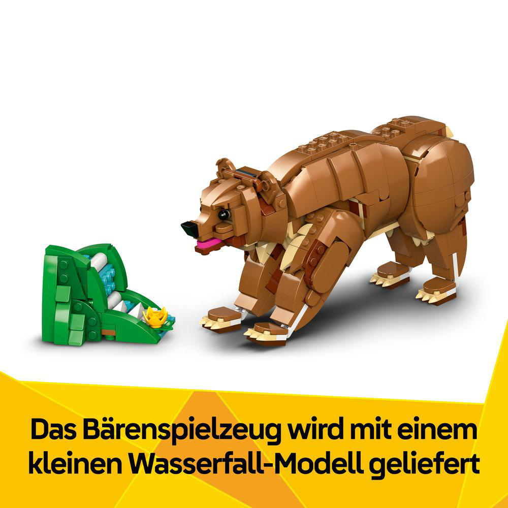 Ein braunes Bärenspielzeug mit einem grünen Wasserfallmodell. Der Bär befindet sich in einer Laufpose. Unten steht: Das Bärenspielzeug wird mit einem kleinen Wasserfallmodell geliefert.