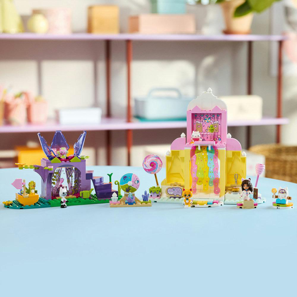 Ein Lego-Set mit bunten Strukturen und Figuren auf blauem Untergrund. Enthält ein rosa Schloss, ein Boot und andere kleine Figuren.