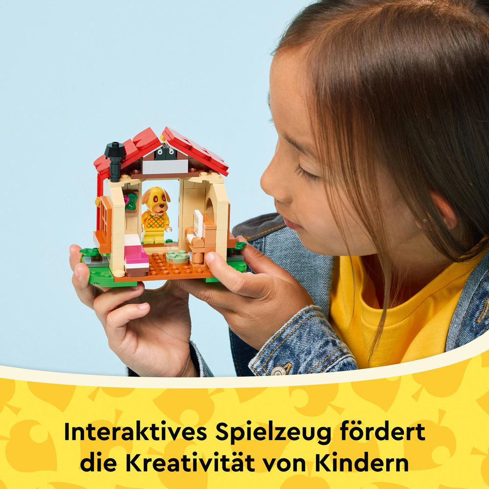 Ein Mädchen betrachtet ein Lego-Haus-Spielzeug. Das Haus ist beige, rot und grün. Im Inneren befindet sich eine Hundefigur. Blauer Hintergrund.