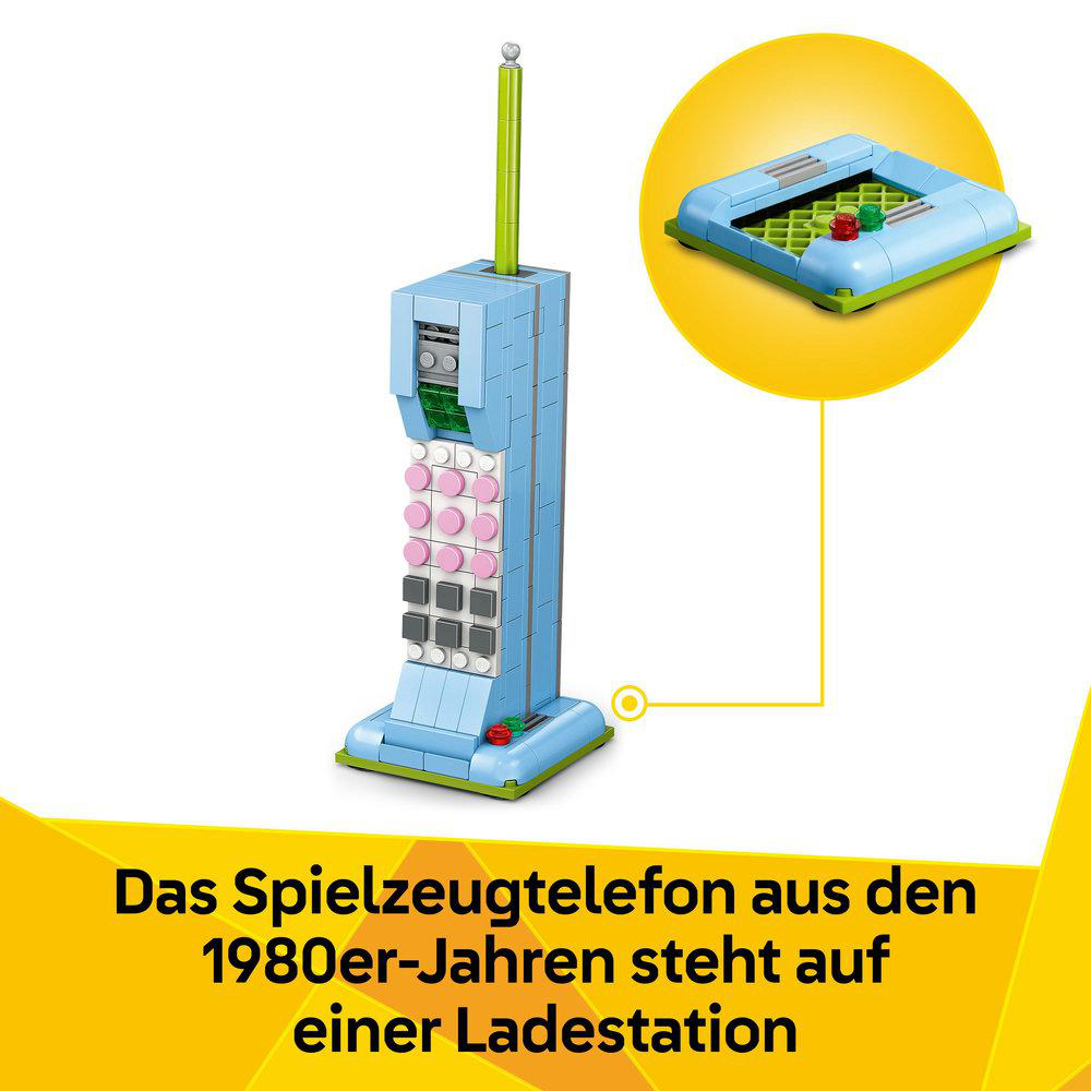 Ein Spielzeugtelefon aus den 1980er Jahren auf einer Ladestation. Das Telefon ist blau mit rosa Knöpfen und einer grünen Antenne.