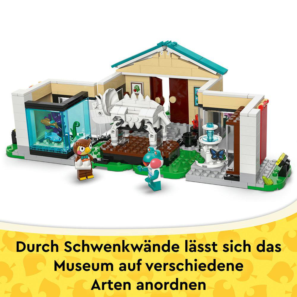 Ein Lego-Museum mit Figuren und Tieren, darunter eine Eule und ein Frosch. Es hat einen Springbrunnen und einen Dinosaurier. Das Museum hat ein beiges Dach.