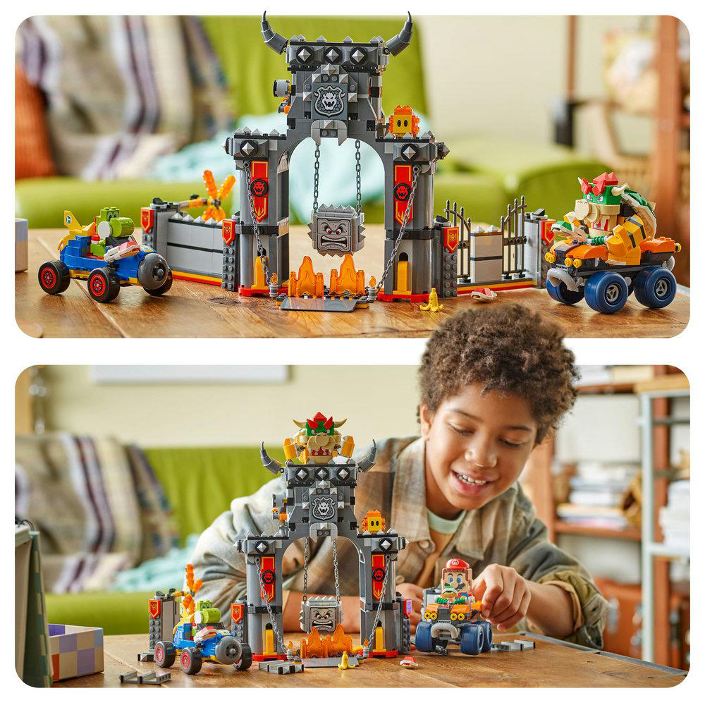 Ein Junge spielt lächelnd mit einem Lego-Set von Bowsers Burg. Das Set enthält Charaktere, Fahrzeuge, Burgstrukturen und Feuerelemente.