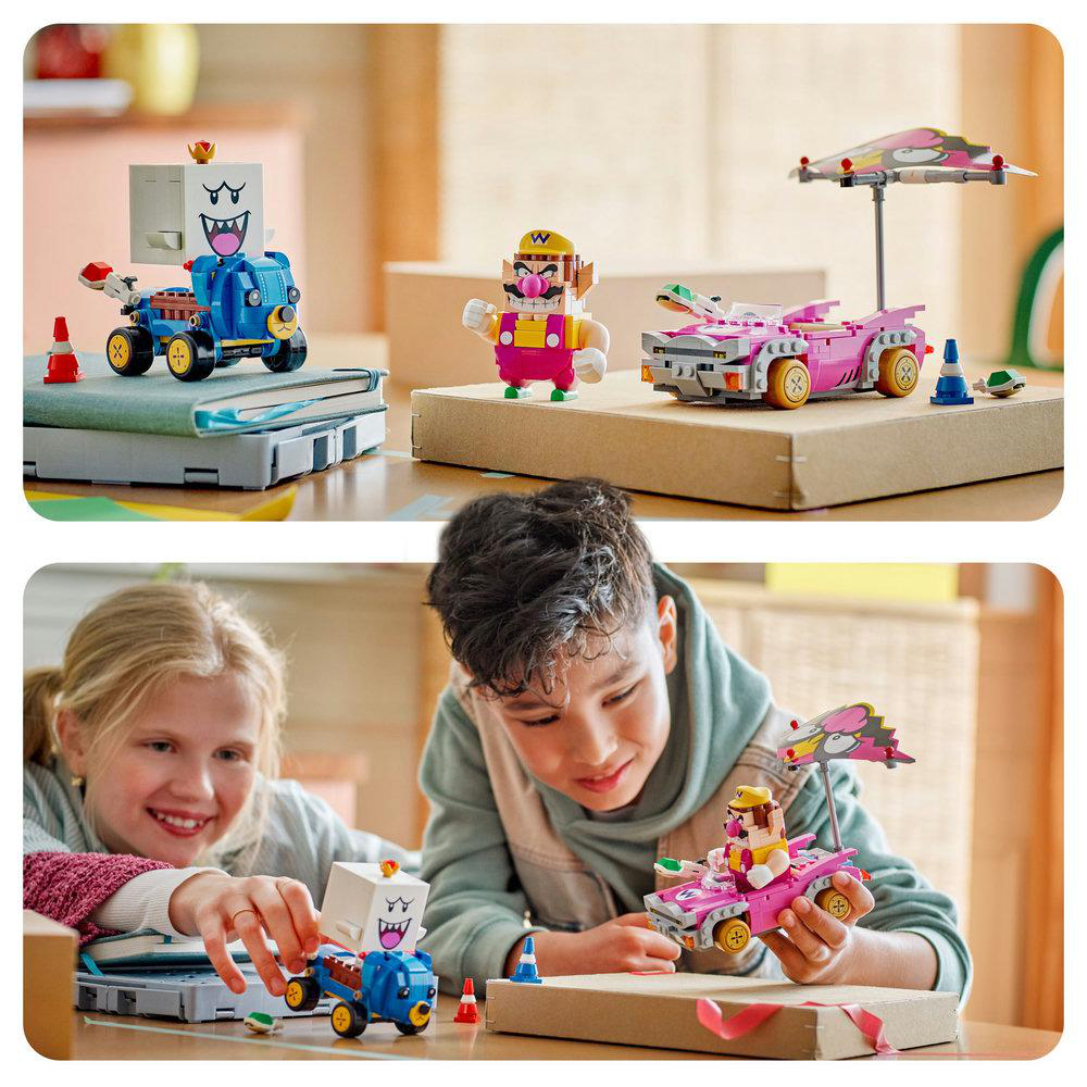 Zwei Kinder spielen mit Lego Mario Kart Sets. Ein Set hat ein pinkes Auto mit einem Regenschirm, das andere ein blaues Motorrad.