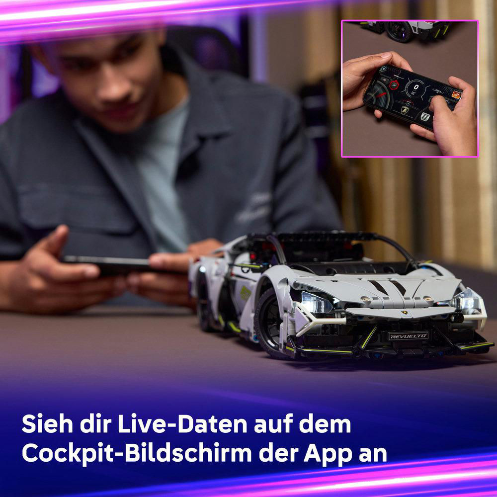 Eine Person hält ein Tablet und schaut sich ein Spielzeugauto an. Eine Hand hält eine Fernbedienung. Das Auto ist weiß und schwarz.