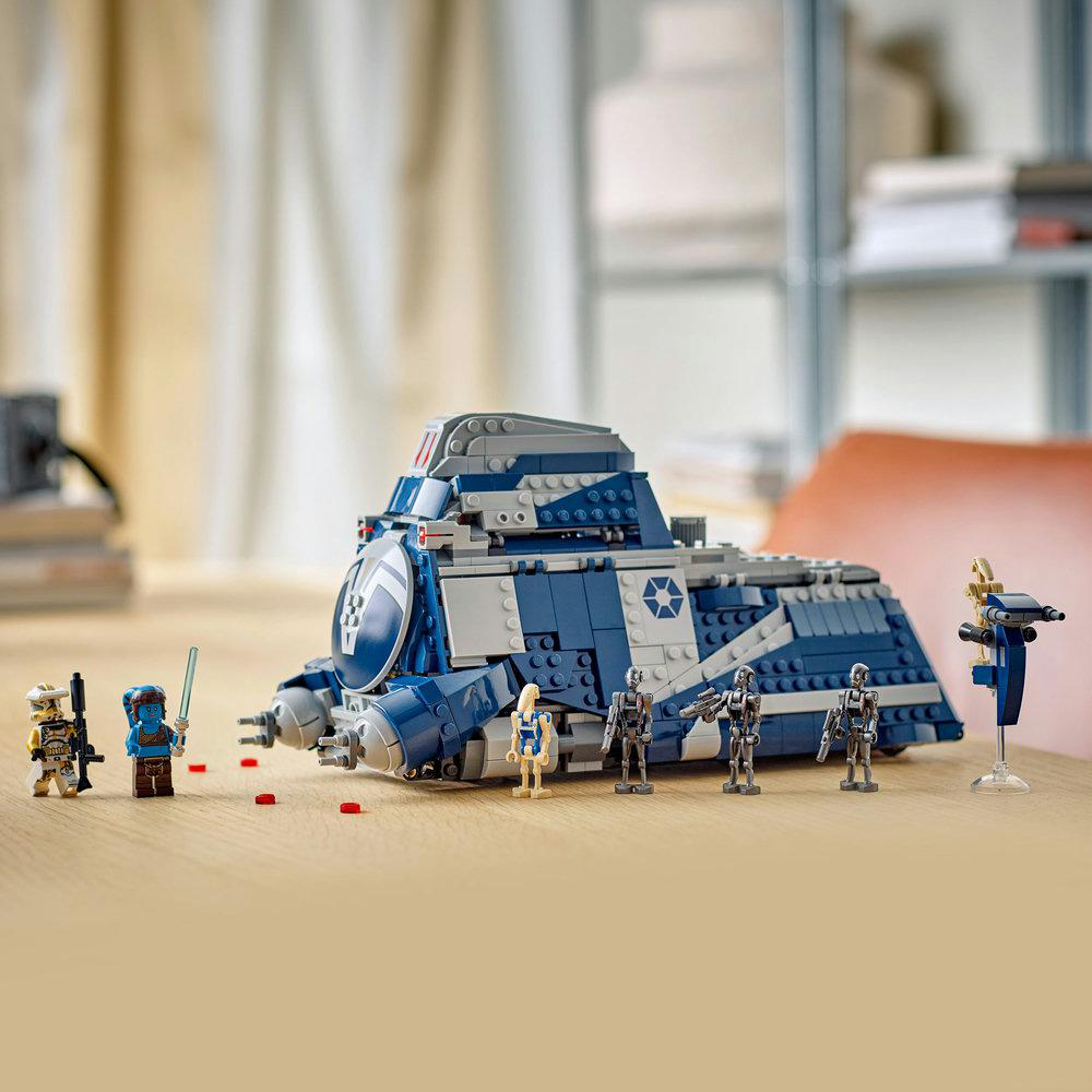 Ein Lego Star Wars Set mit einem blau-grauen Fahrzeug und mehreren Mini-Figuren auf einem Holztisch. Der Hintergrund zeigt einen Raum.