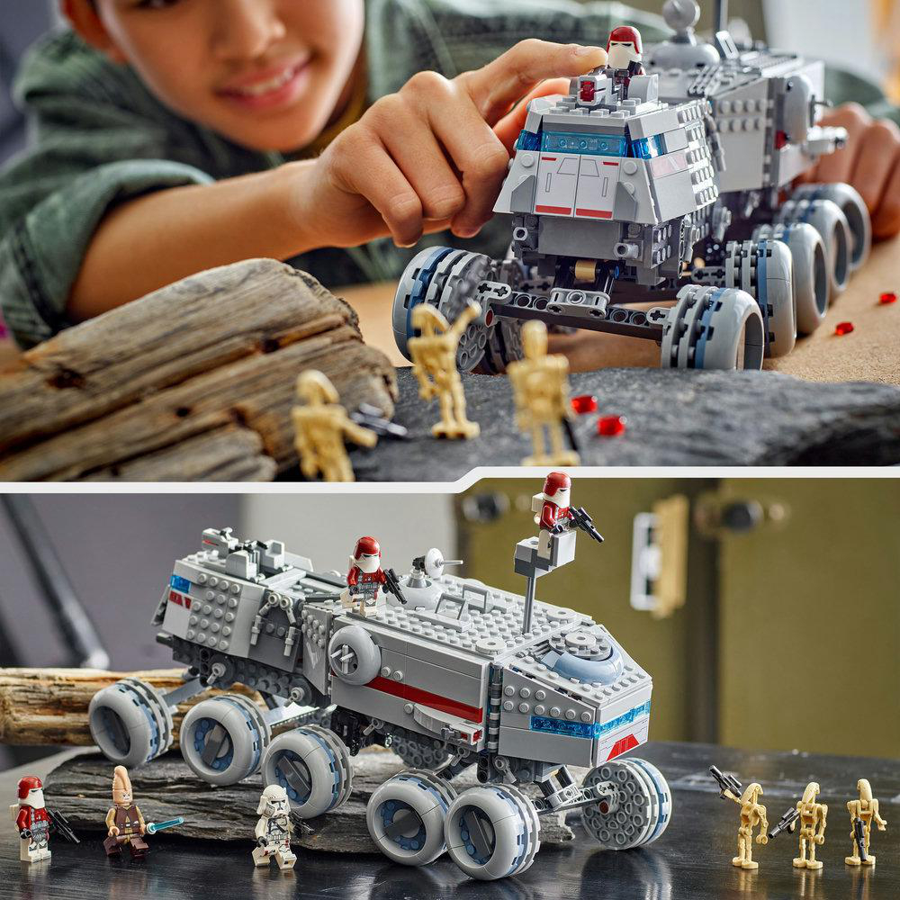 Ein Kind spielt mit einem LEGO Star Wars Modell. Es zeigt ein graues Fahrzeug mit mehreren Rädern, Minifiguren und einen felsigen Hintergrund.