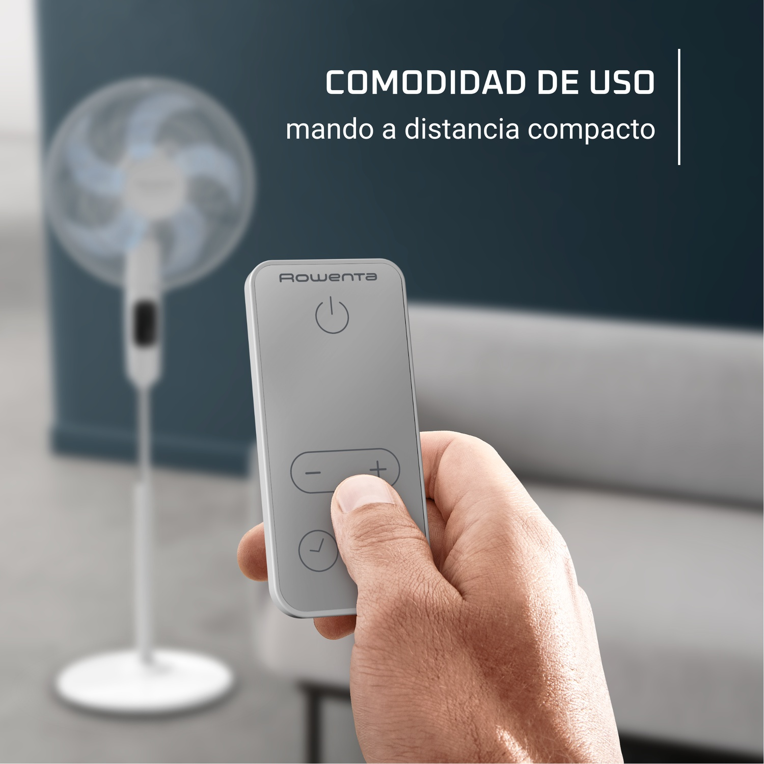 Une main tient une télécommande grise. Un ventilateur blanc en arrière-plan. Texte : COMODIDAD DE USO, mando a distancia compacto.