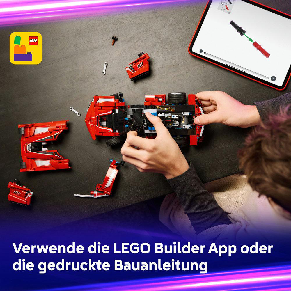 Person baut rotes LEGO-Auto zusammen. Teile liegen verstreut auf dunkler Oberfläche. Tablet zeigt Anweisungen. LEGO-Logo sichtbar.