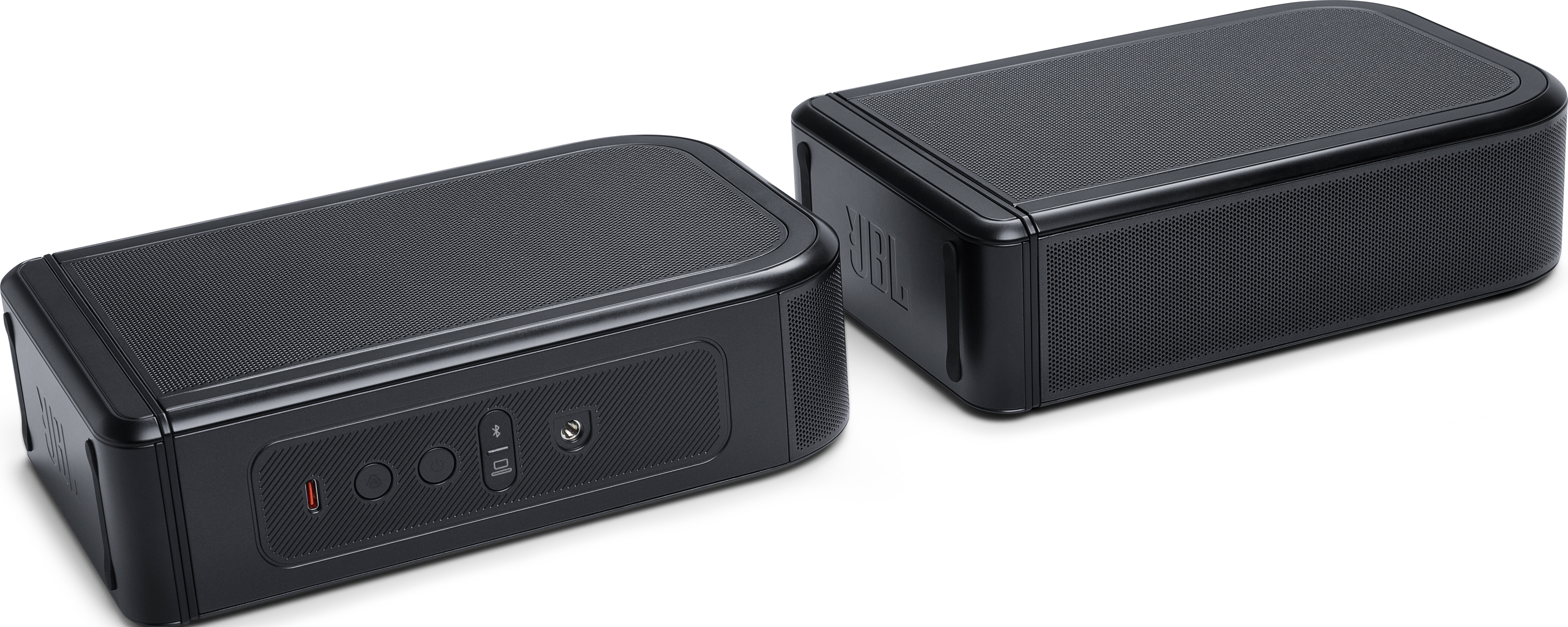 Zwei schwarze, rechteckige JBL-Lautsprecher stehen auf einer weißen Oberfläche. Sie haben Mesh-Oberseiten und Bedienfelder mit Anschlüssen. Das JBL-Logo ist sichtbar.