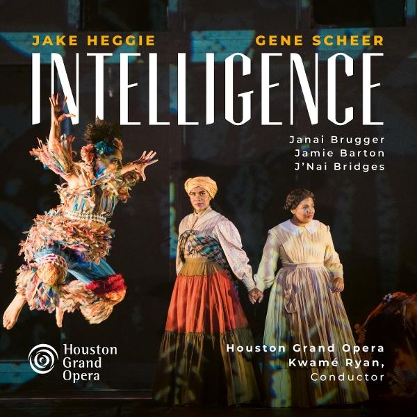 Opernplakat. Titel: Intelligence. Darsteller sind zu sehen. Kostüme umfassen bunte Federn und historische Kleider.