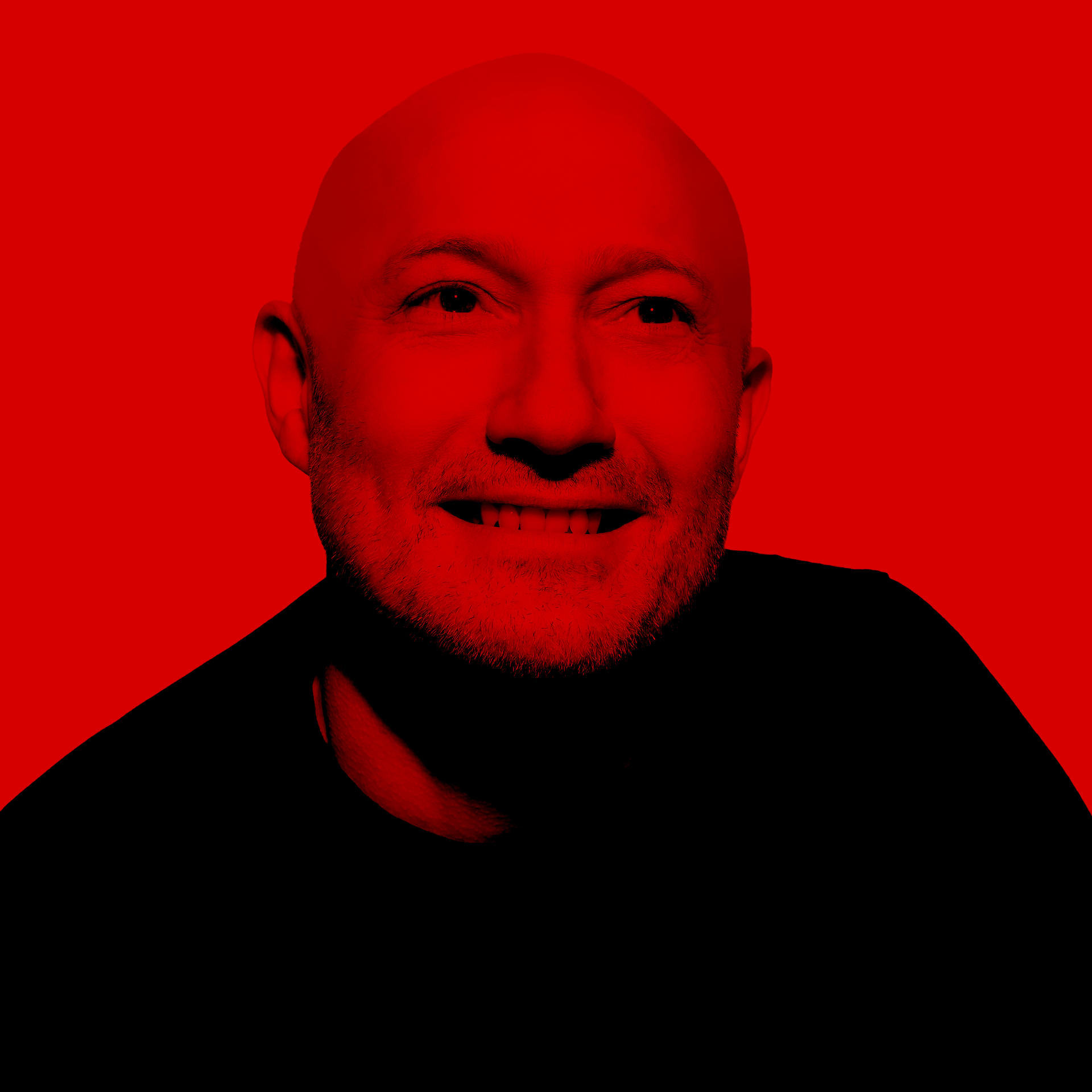 Glatzköpfiger Mann mit Bart lächelt. Roter Hautton. Schwarzes Hemd auf rotem Hintergrund.