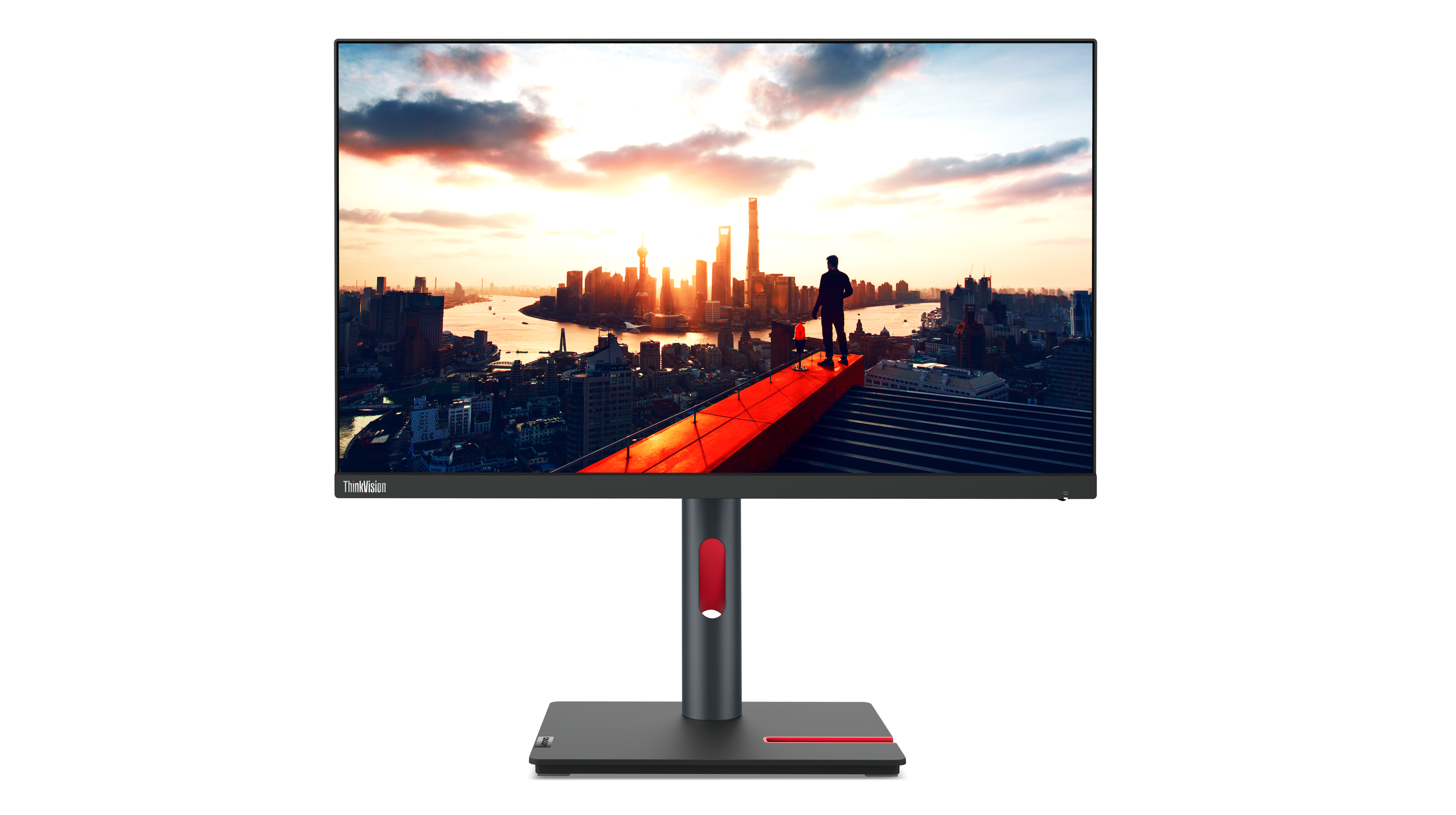 Ein Monitor zeigt eine Skyline bei Sonnenuntergang. Eine Person steht auf einem roten Weg und blickt über die Gebäude. Der Monitor hat einen roten und grauen Ständer.