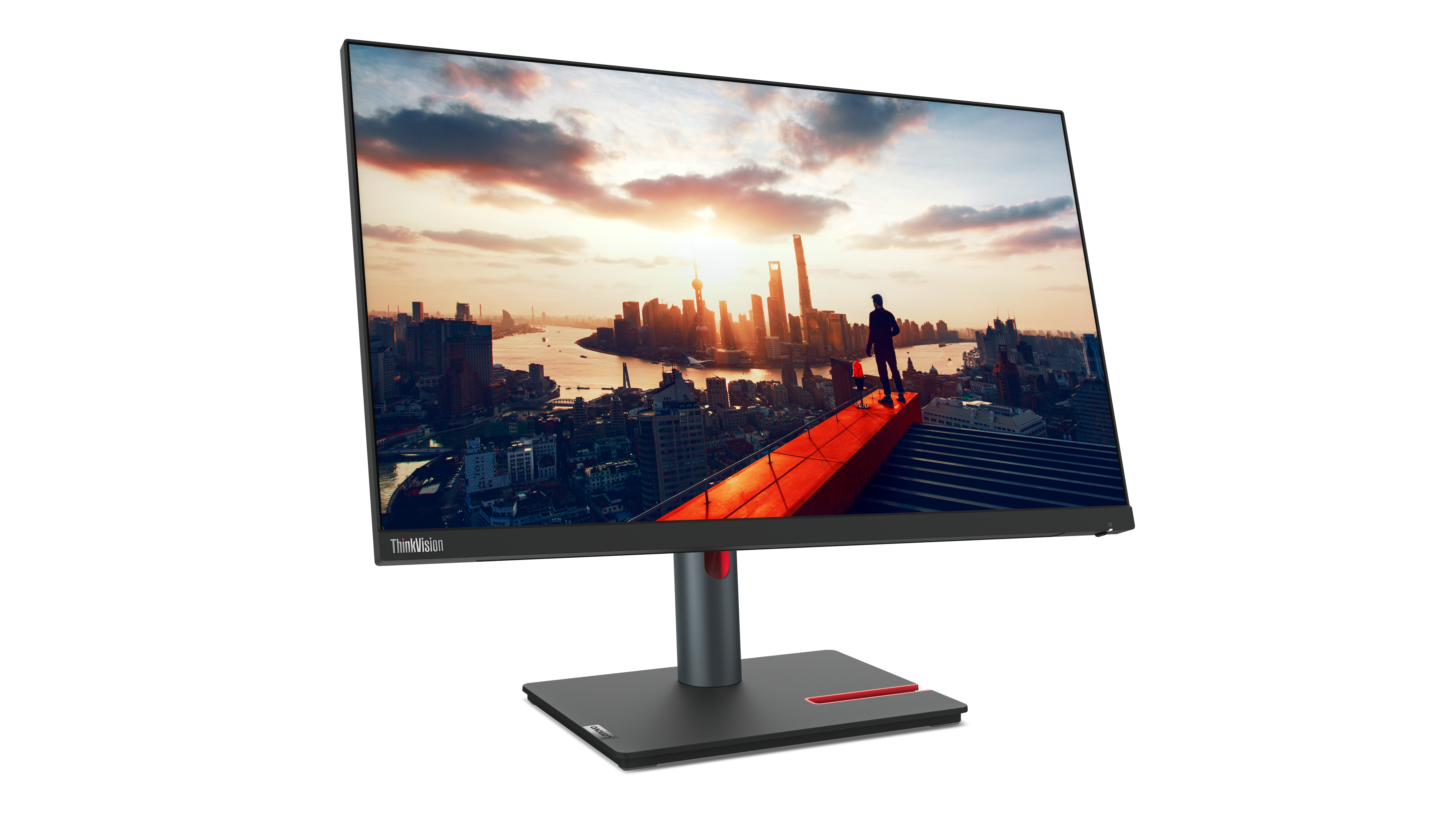 Ein Lenovo-Monitor zeigt eine Stadtlandschaft bei Sonnenuntergang. Eine Person steht auf einer roten Plattform. Der Monitor hat einen schwarzen Ständer.