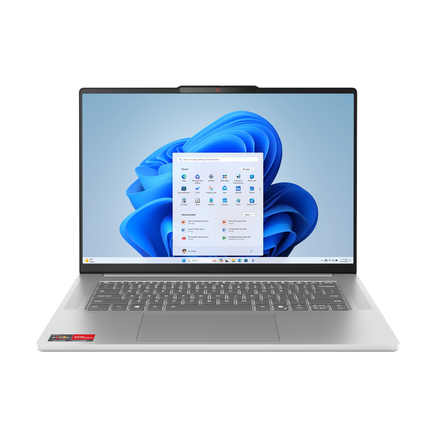 Un ordinateur portable argenté est ouvert, affichant le bureau Windows 11. L'écran montre des icônes d'applications et une barre de recherche. Le clavier est visible.