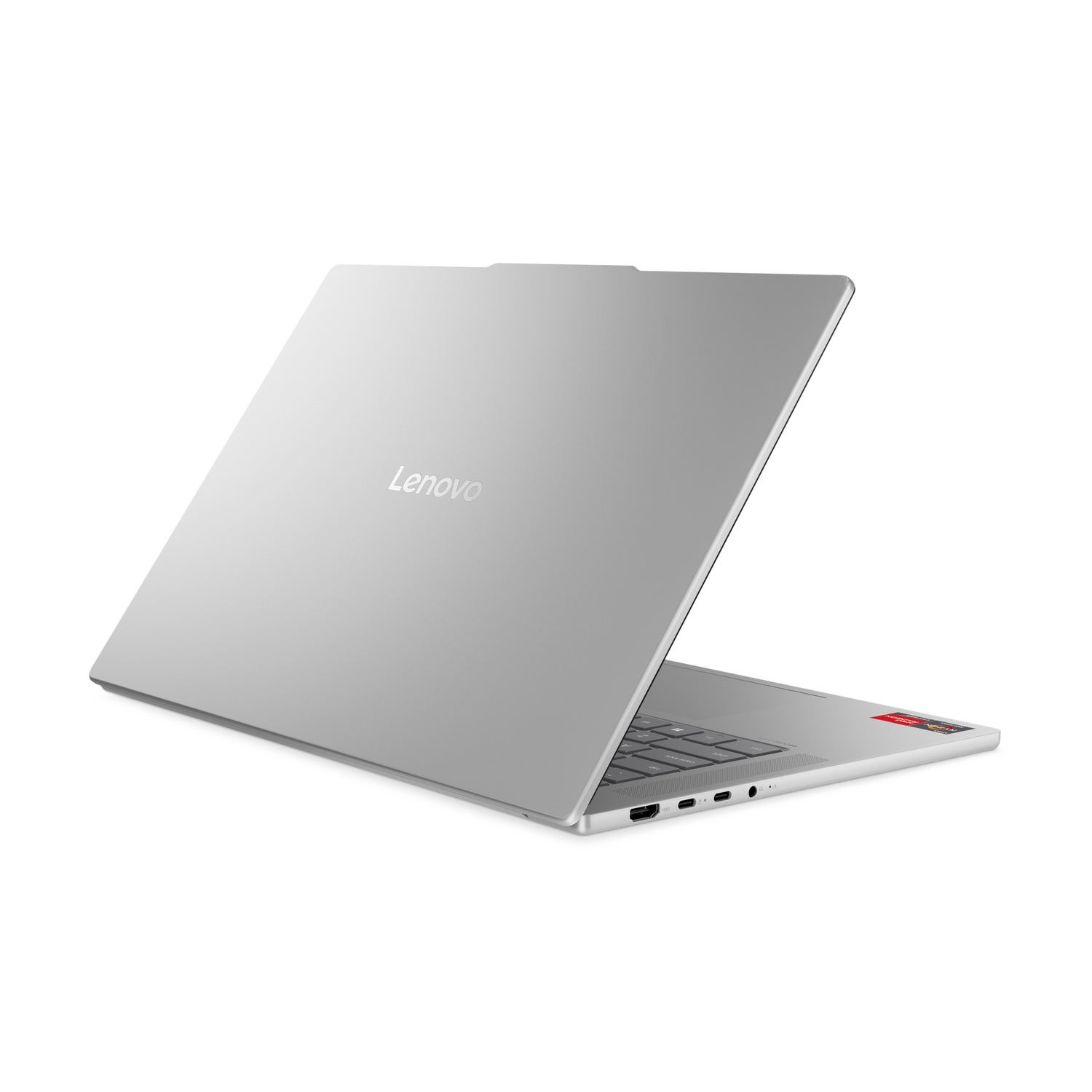 Ordinateur portable Lenovo argenté, légèrement ouvert, sur fond blanc. Le logo Lenovo est visible. Les ports et le clavier sont également visibles.