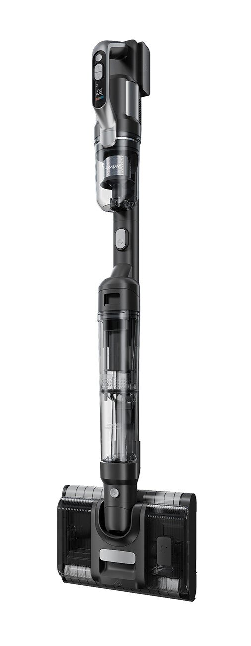 Czarno-szary odkurzacz bezprzewodowy stoi pionowo. Ma przezroczysty pojemnik na kurz i prostokątną głowicę szczotkową.