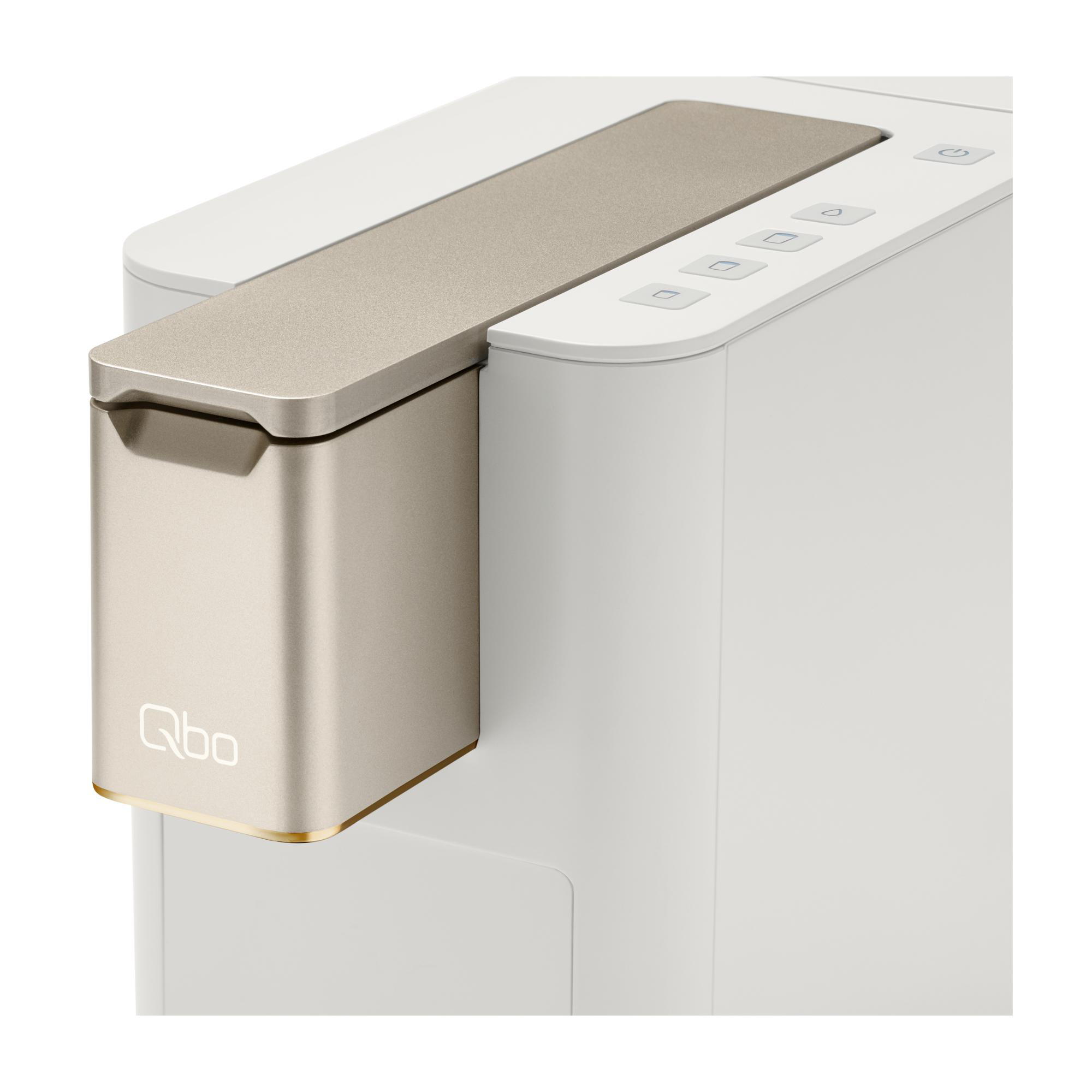 Ein weißes und goldenes Gerät mit Knöpfen und einem goldenen Oberteil. Der Markenname 'Qbo' ist sichtbar.