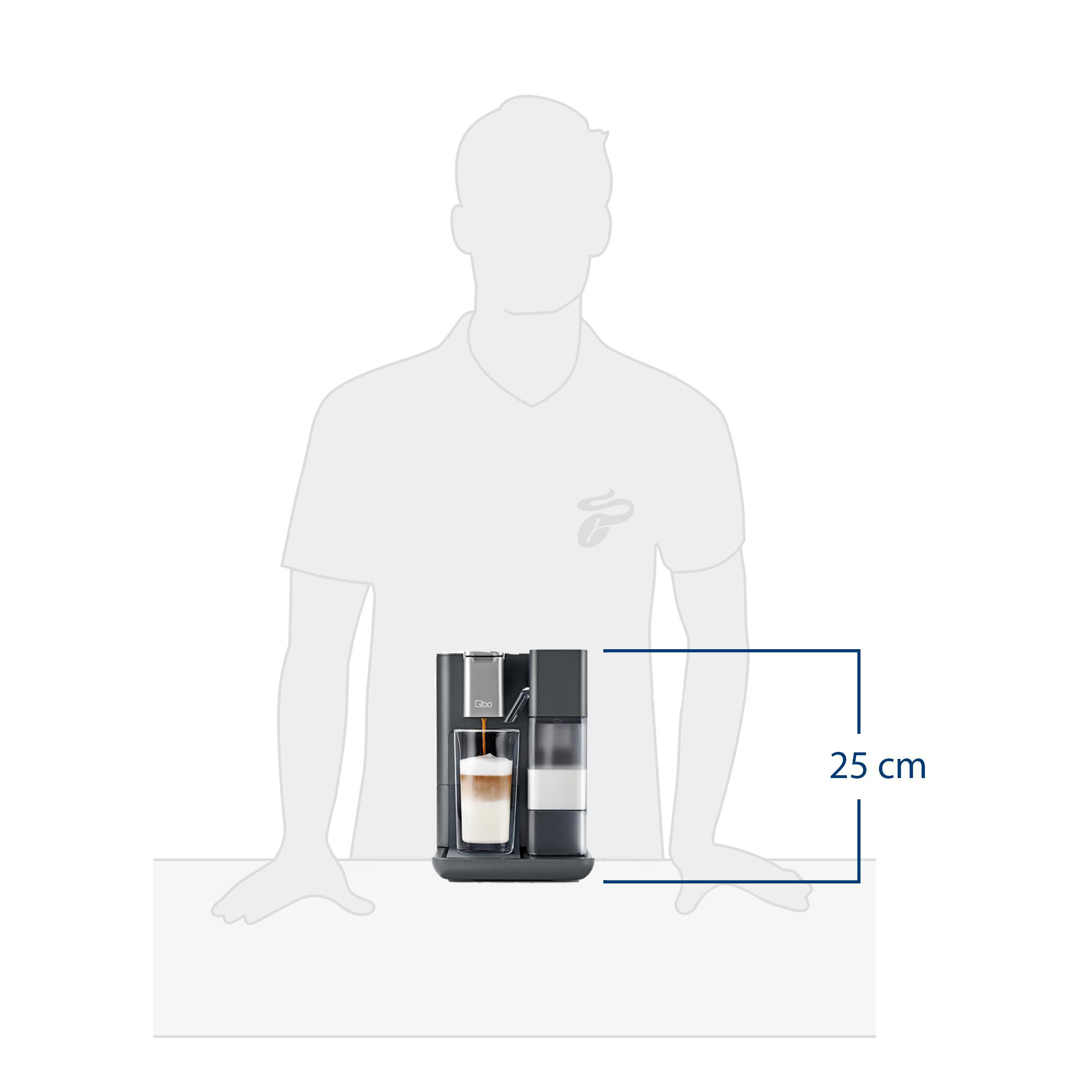 Eine Kaffeemaschine mit einem Glas geschichteten Kaffees wird gezeigt, neben einem Milchbehälter. Eine Person steht dahinter.